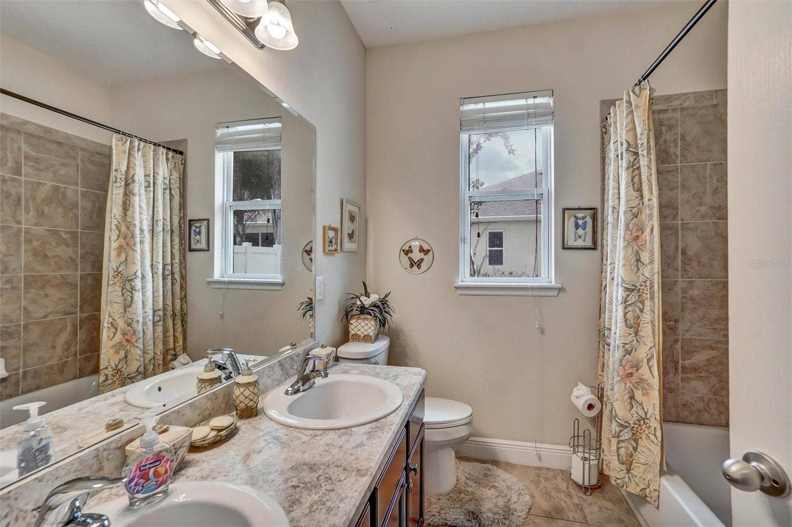 Second BathroomGuest bathroom featuring a spacious vanity, tiled walls, tub, and natural light.