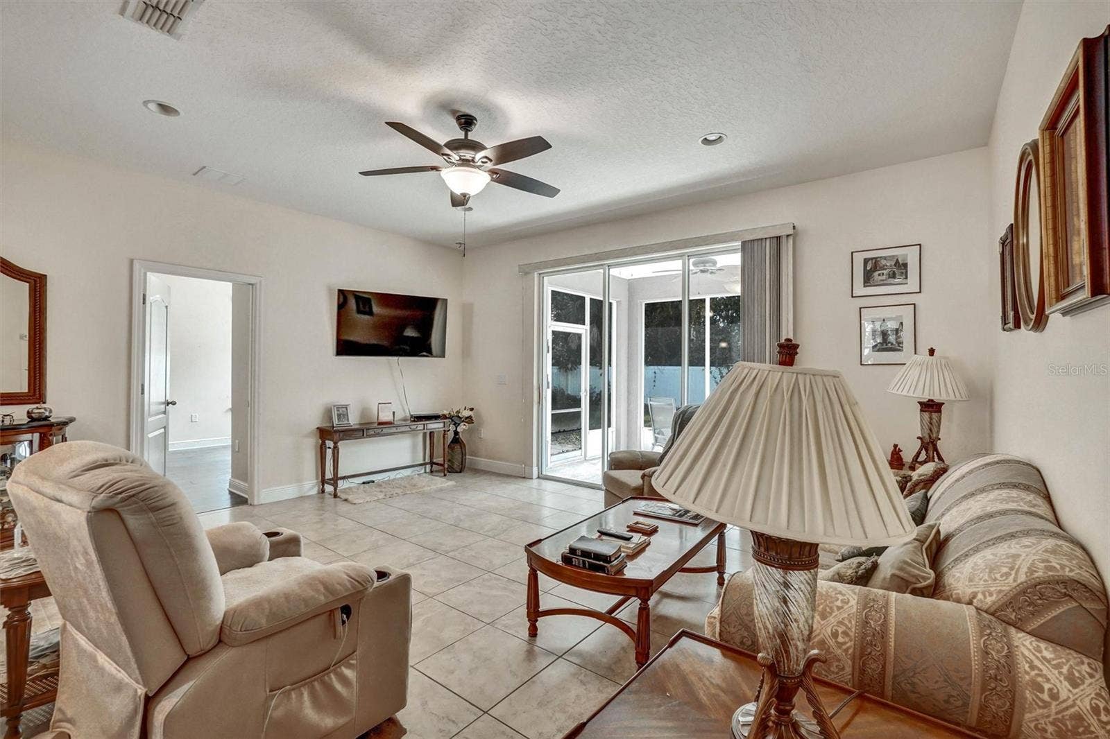 Living RoomSpacious living room with tile flooring and sliding glass doors.