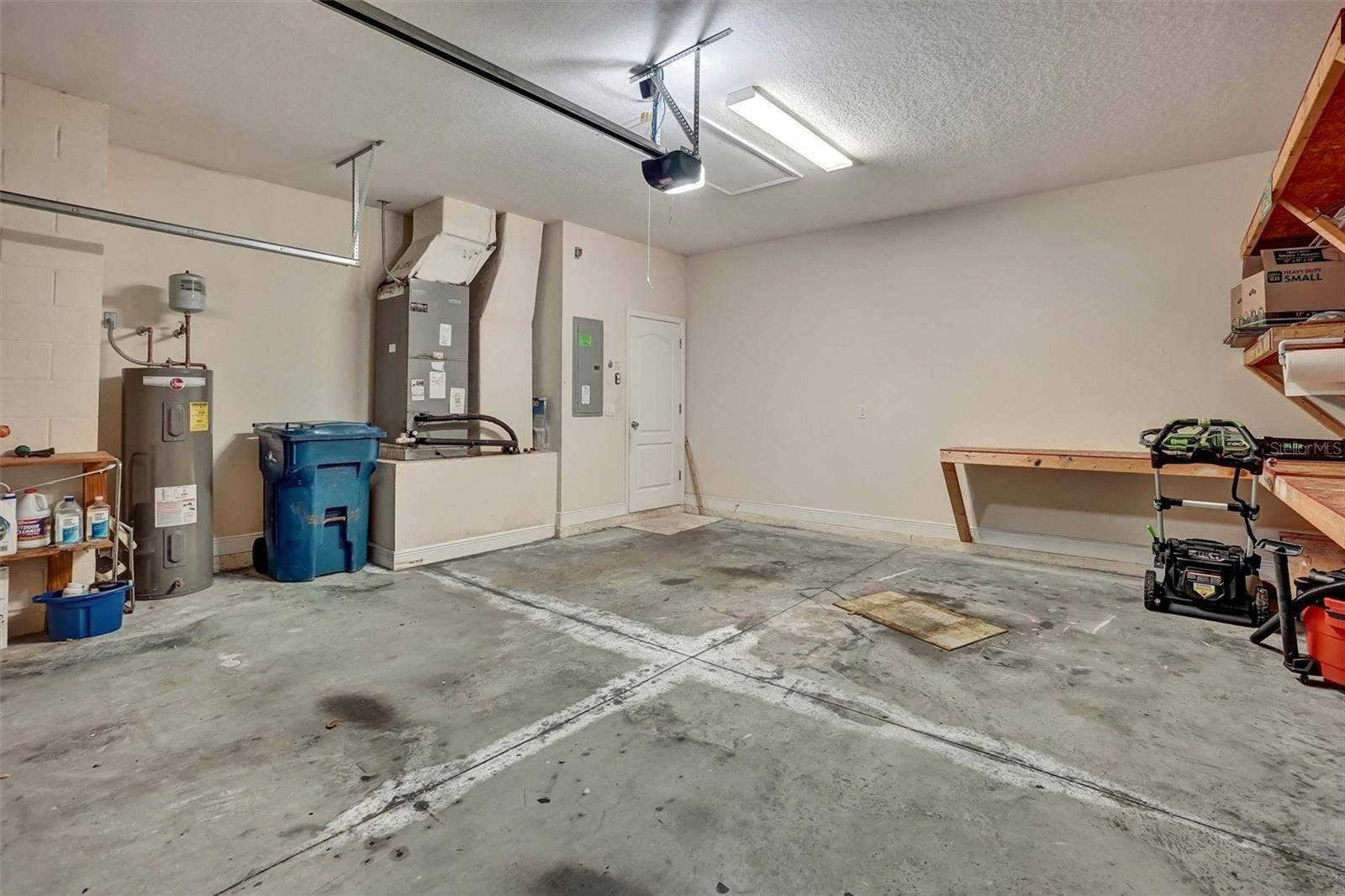 Spacious two-car garage with built-in storage, workbenches, and utility access.
