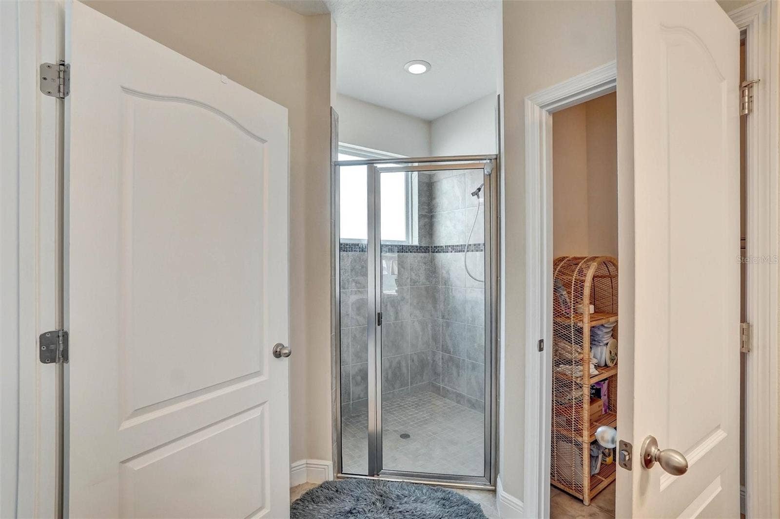 Walk-In ShowerSpacious shower with tiled walls, glass doors, and built-in lighting.