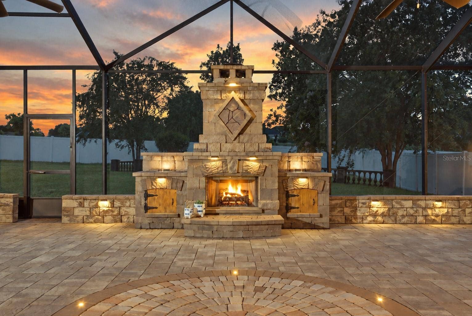 230 LAKE ARIETTA COURT, Auburndale, FL 33823 lanai at twilight with waterfalls and fireplace