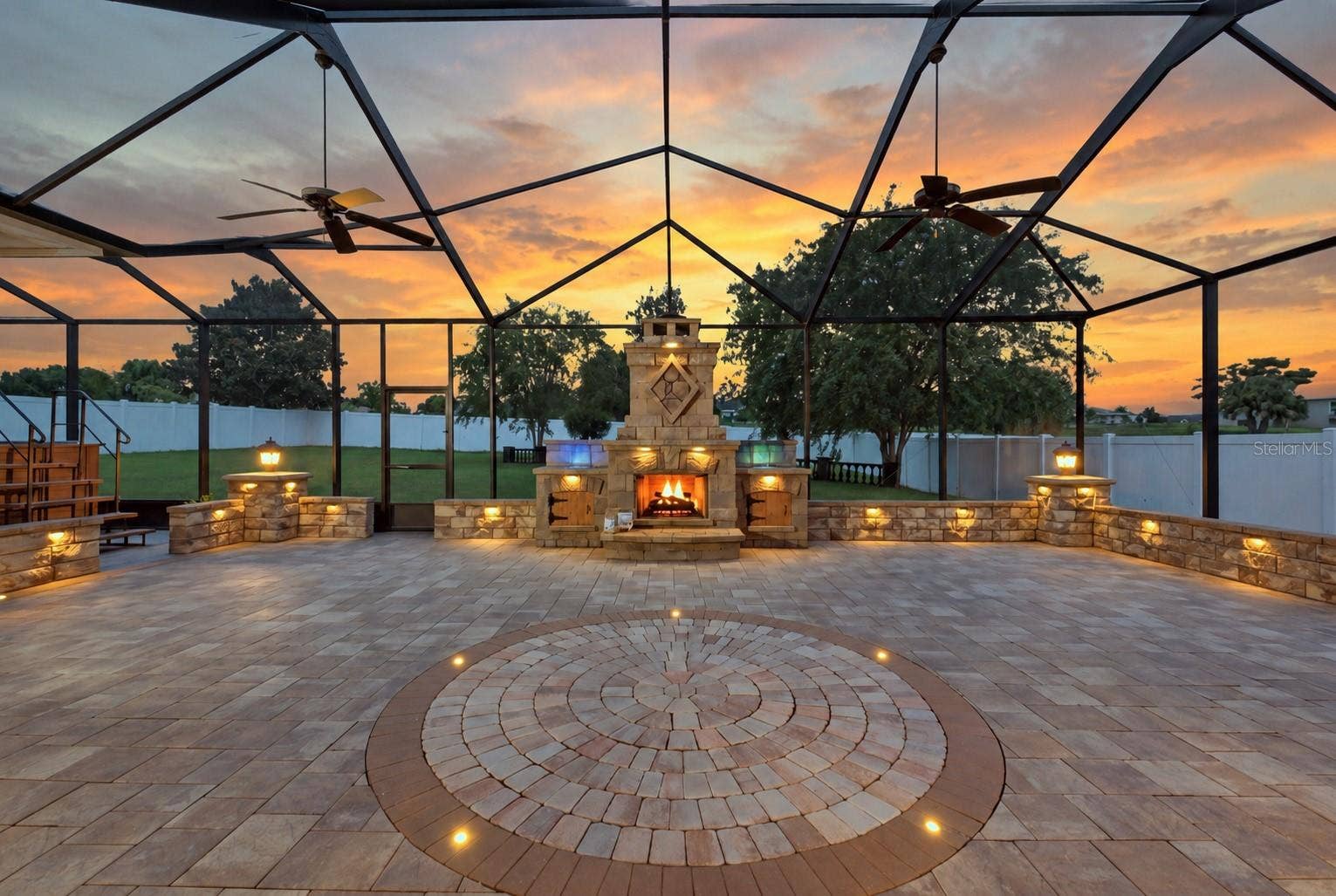 230 LAKE ARIETTA COURT, Auburndale, FL 33823 lanai at twilight with waterfalls and fireplace