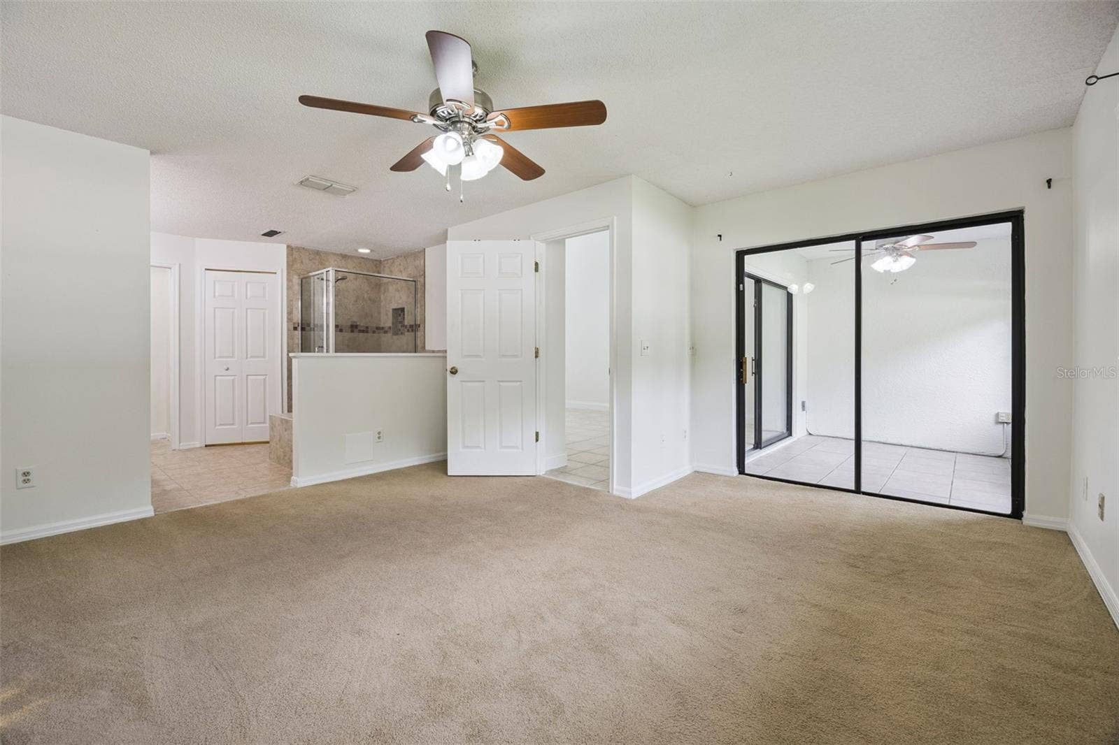8370 SANDPOINT BLVD, Orlando, FL 32819 Primary bedroom with access to patio/lanai