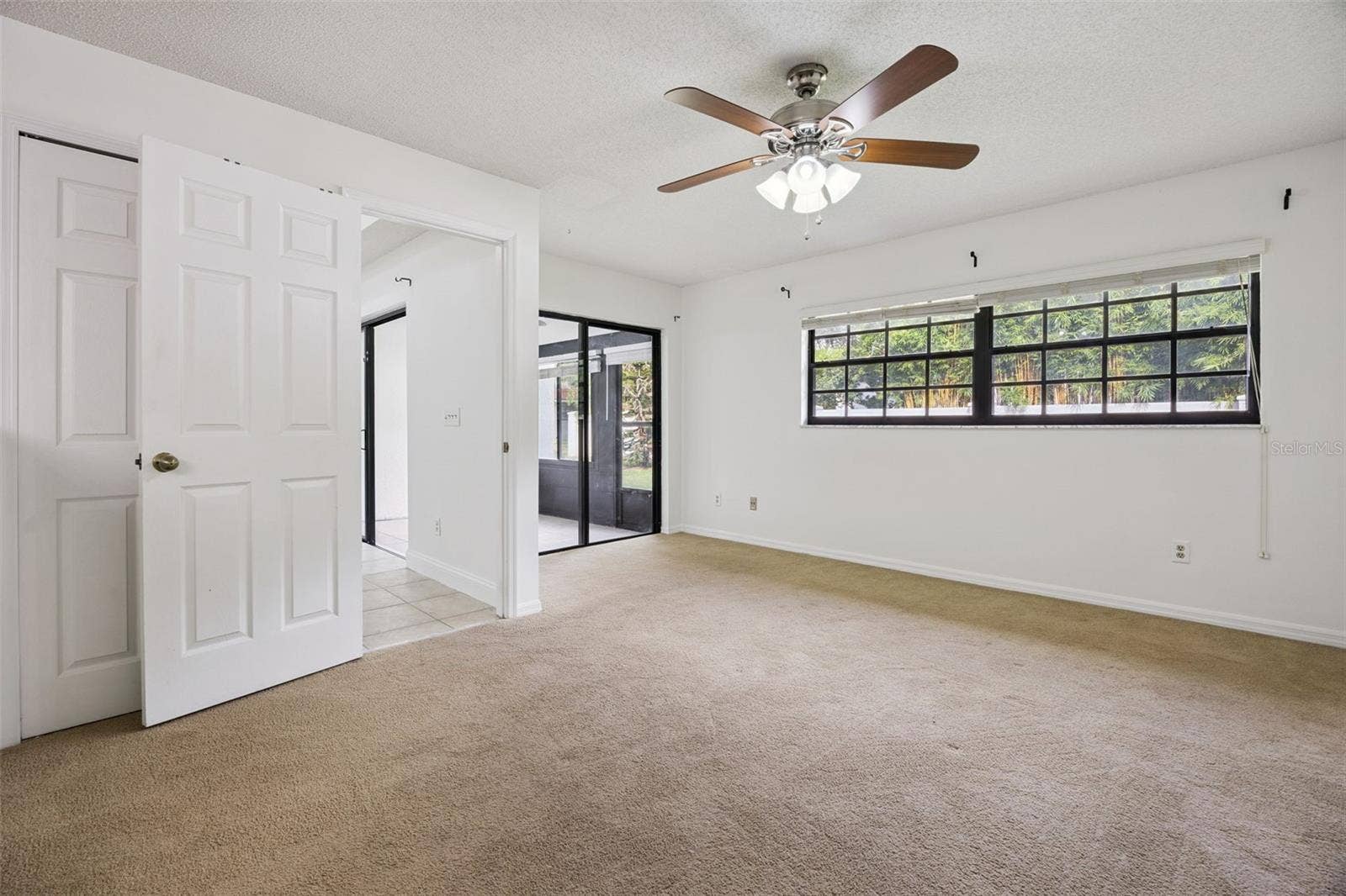 8370 SANDPOINT BLVD, Orlando, FL 32819 Primary bedroom with access to patio/lanai
