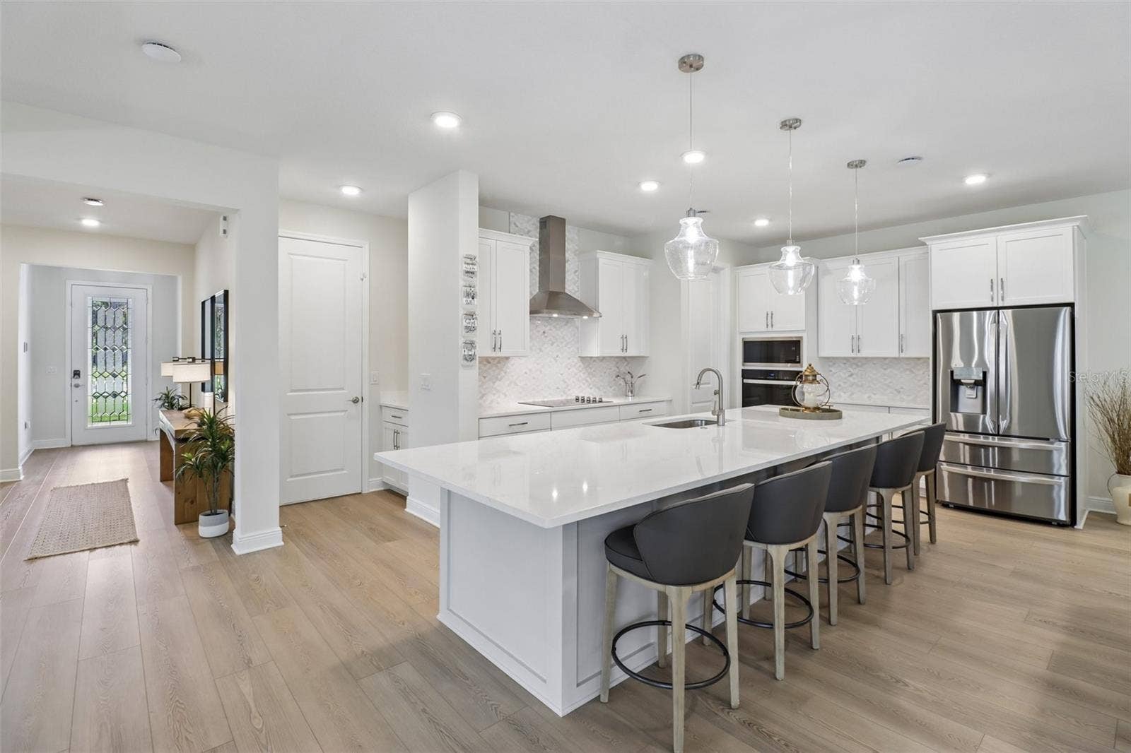2985 WATER CLOVER COURT, Apopka, FL 32712 The OPEN-CONCEPT MAIN FLOOR centers around a must-see CHEF'S KITCHEN featuring sleek countertops, extensive cabinetry and storage, a decorative backsplash, pendant lighting, built-in STAINLESS STEEL APPLIANCES and a HUGE ISLAND with bar seating.