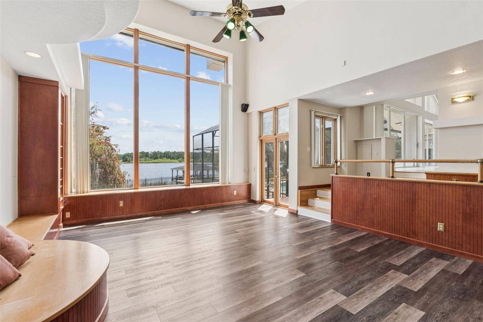 4301 DOWN POINT LANE, Windermere, FL 34786 Sunken great room with soaring ceilings, lake-view windows, and French doors opening to the pool deck and lanai.