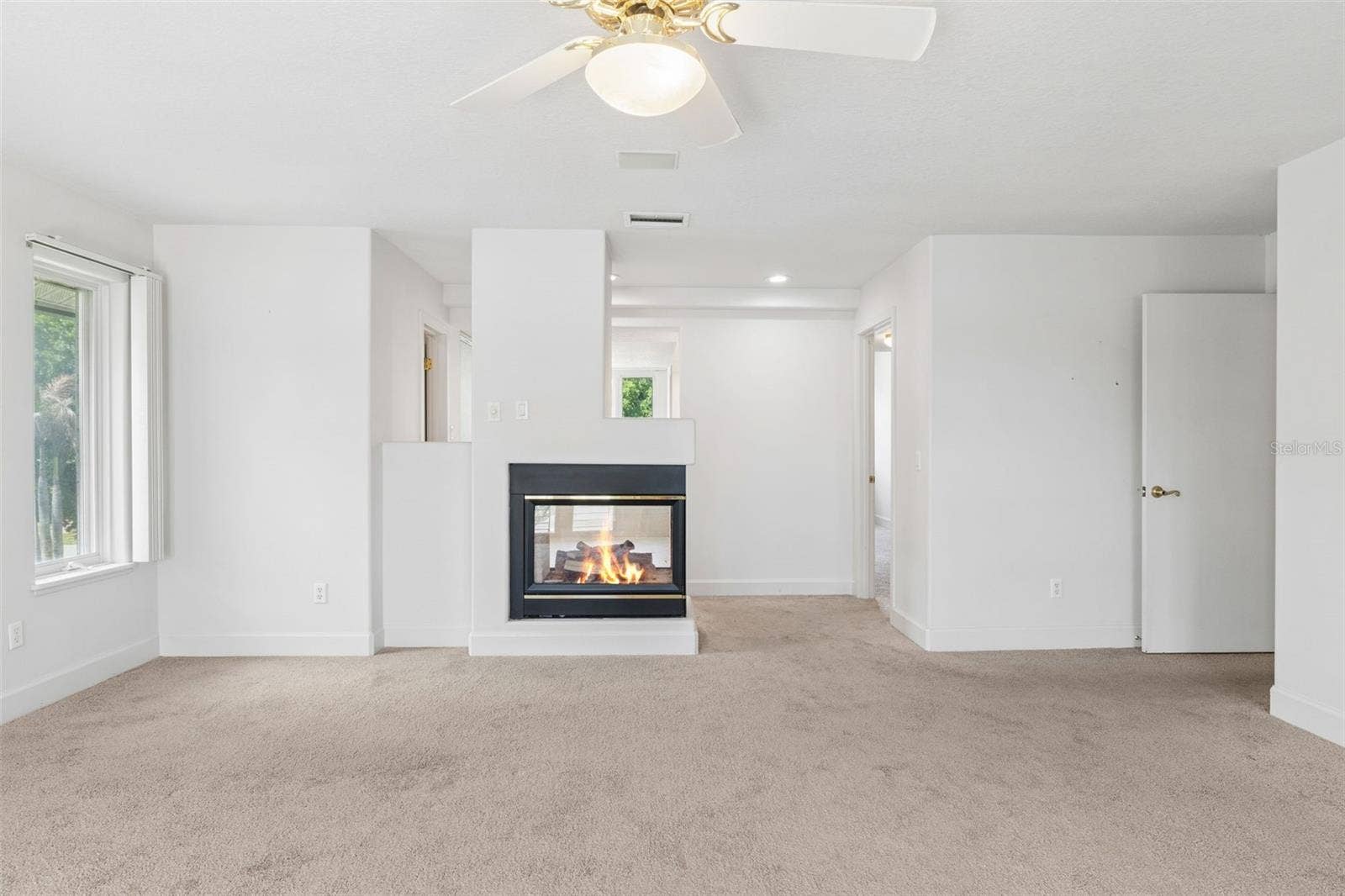 4301 DOWN POINT LANE, Windermere, FL 34786 Primary bedroom with fireplace, private bath access, and spacious walk-in closet.