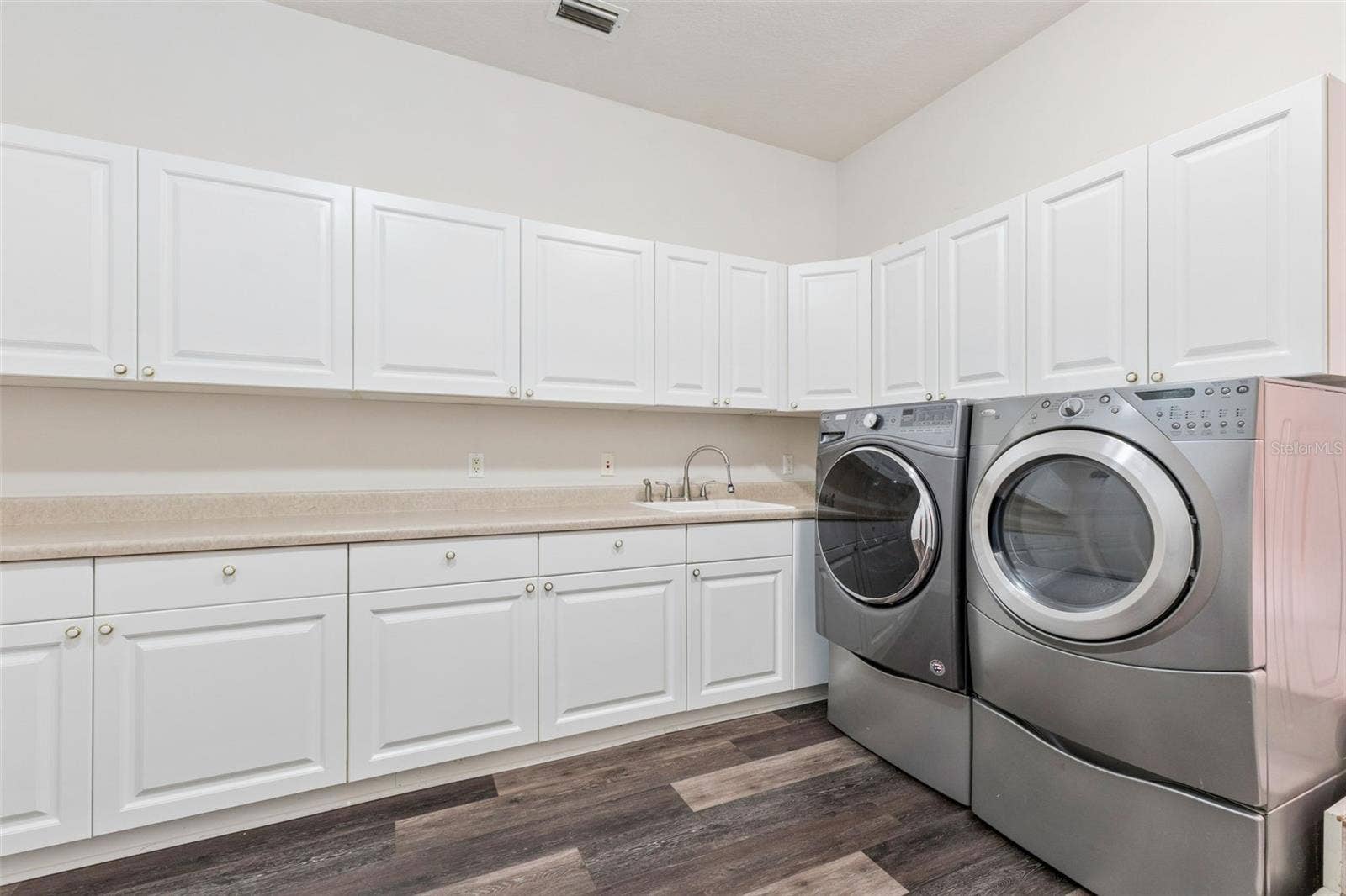4301 DOWN POINT LANE, Windermere, FL 34786 Oversized laundry room with extensive cabinetry, countertop workspace, and utility sink.