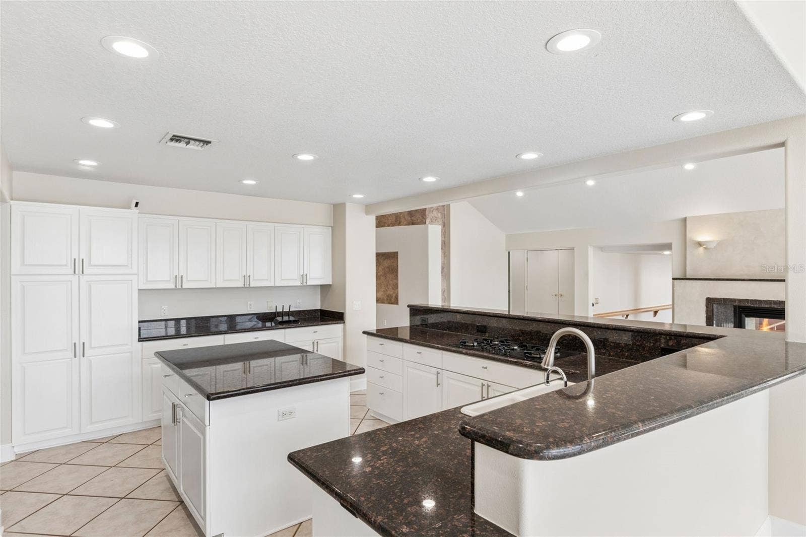4301 DOWN POINT LANE, Windermere, FL 34786 Spacious open kitchen with center island, abundant cabinetry, and views into the living room fireplace.