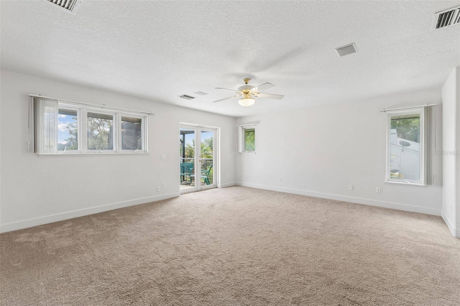 4301 DOWN POINT LANE, Windermere, FL 34786 Spacious primary bedroom with beautiful lake views and French doors opening to a private balcony.