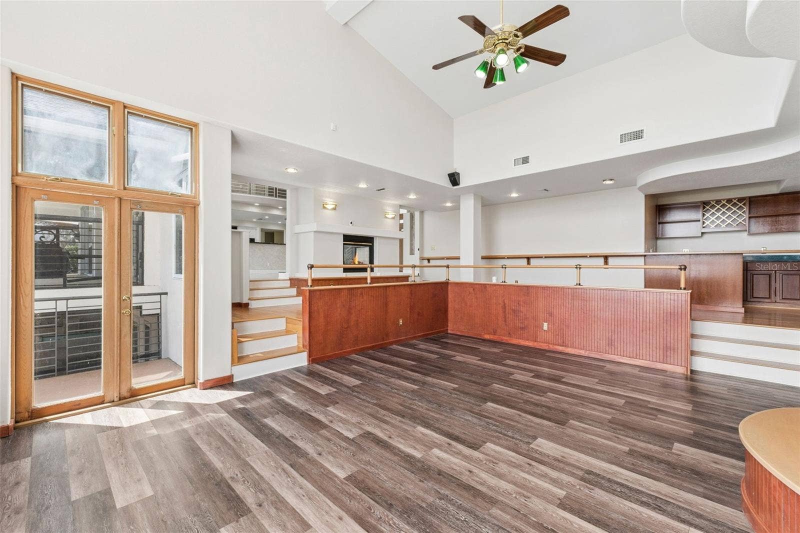 4301 DOWN POINT LANE, Windermere, FL 34786 Sunken great room with soaring ceilings, lake-view windows, and French doors opening to the pool deck and lanai.