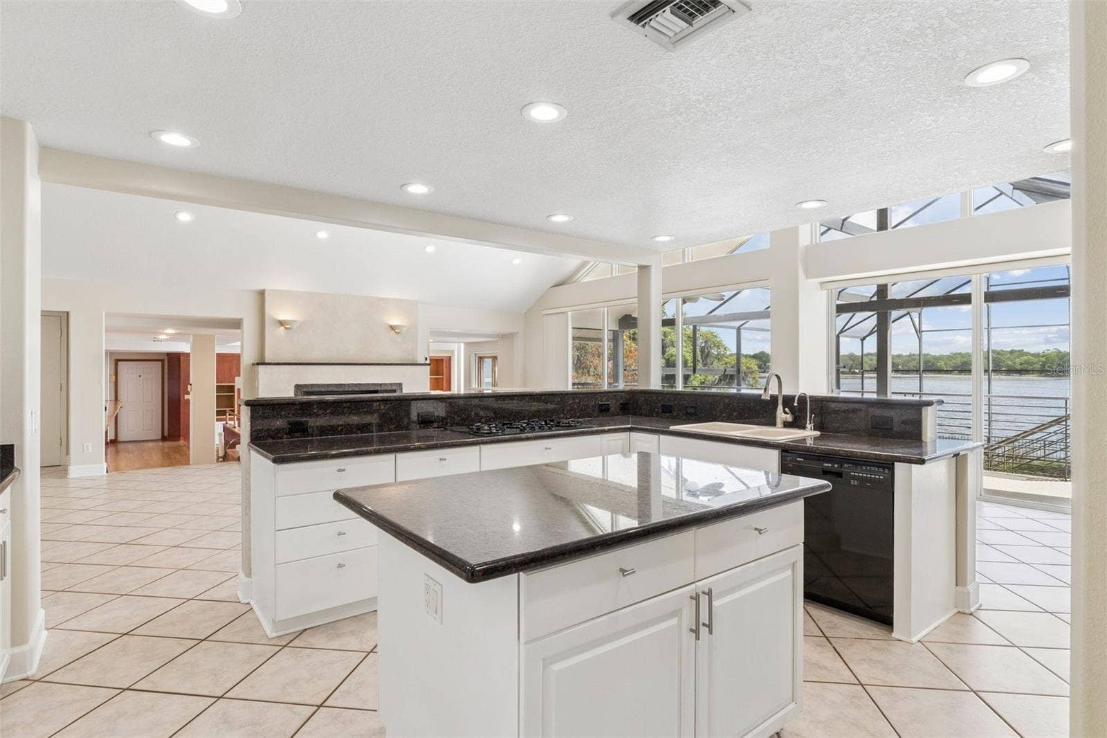 4301 DOWN POINT LANE, Windermere, FL 34786 Open kitchen with center island overlooking the living room, sunken great room, and stunning lake views.