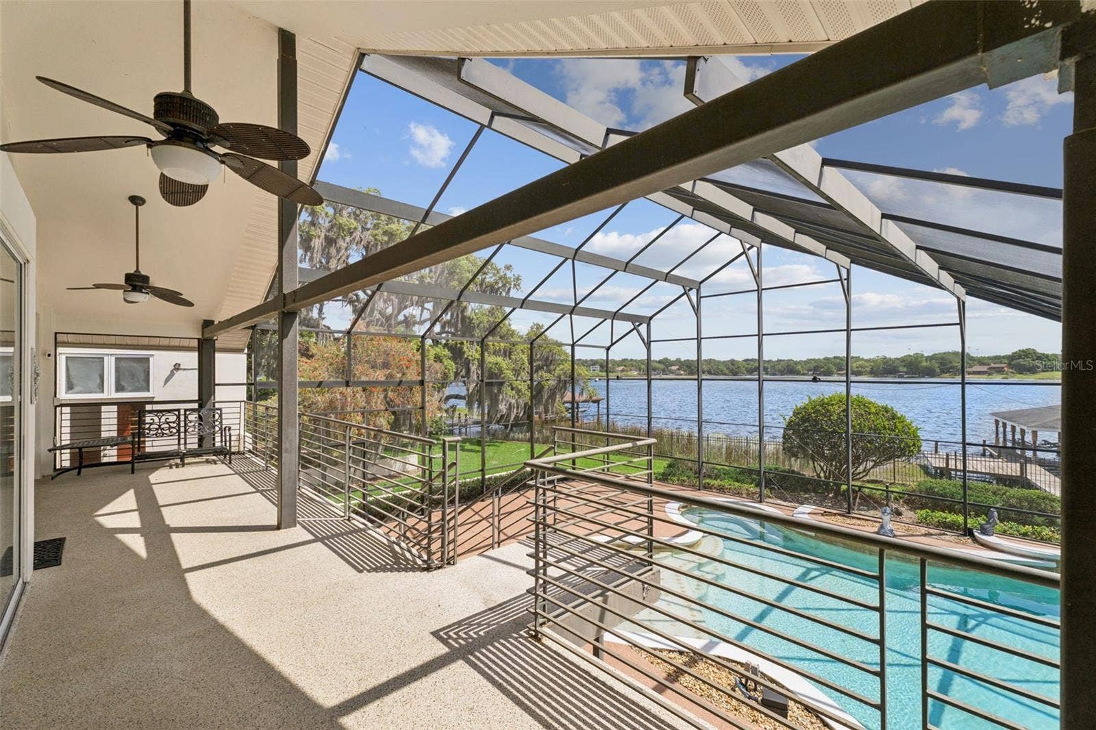 4301 DOWN POINT LANE, Windermere, FL 34786 Main-level screened lanai overlooking the pool and lake, connected to the dining, kitchen, living, and great room areas.