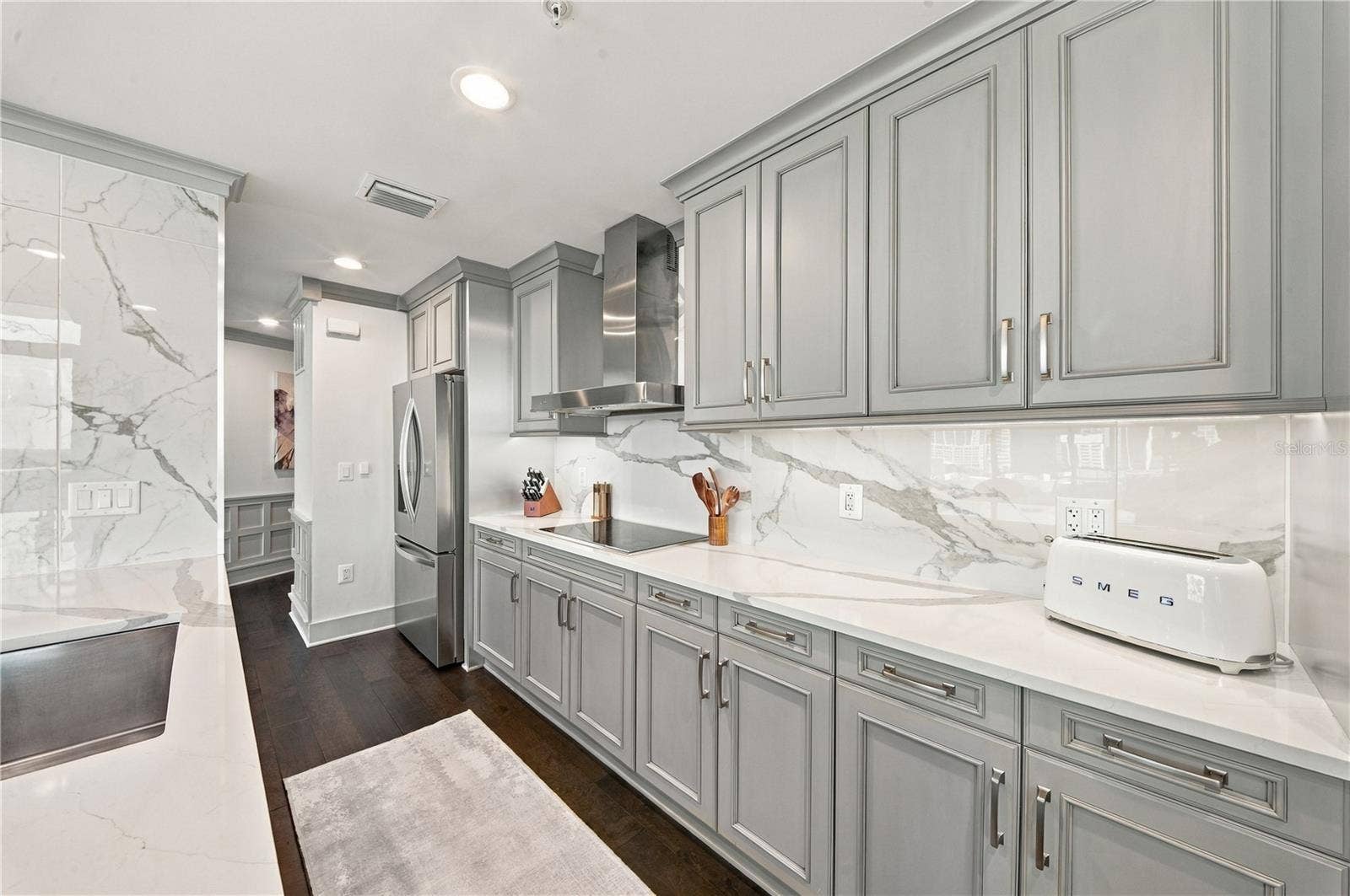 260 S OSCEOLA AVENUE, #1406, Orlando, FL 32801 Kitchen | Quartzite countertops and full-height slab backsplash pair with streamlined cabinetry