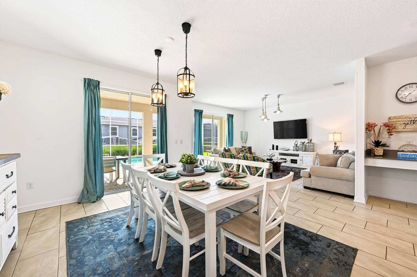 1045 LEADER STREET, Davenport, FL 33896 TWO SETS OF SLIDING GLASS DOORS bring in abundant natural light and create a seamless connection to the pool area, while CONTEMPORARY LIGHTING throughout adds a polished finishing touch.