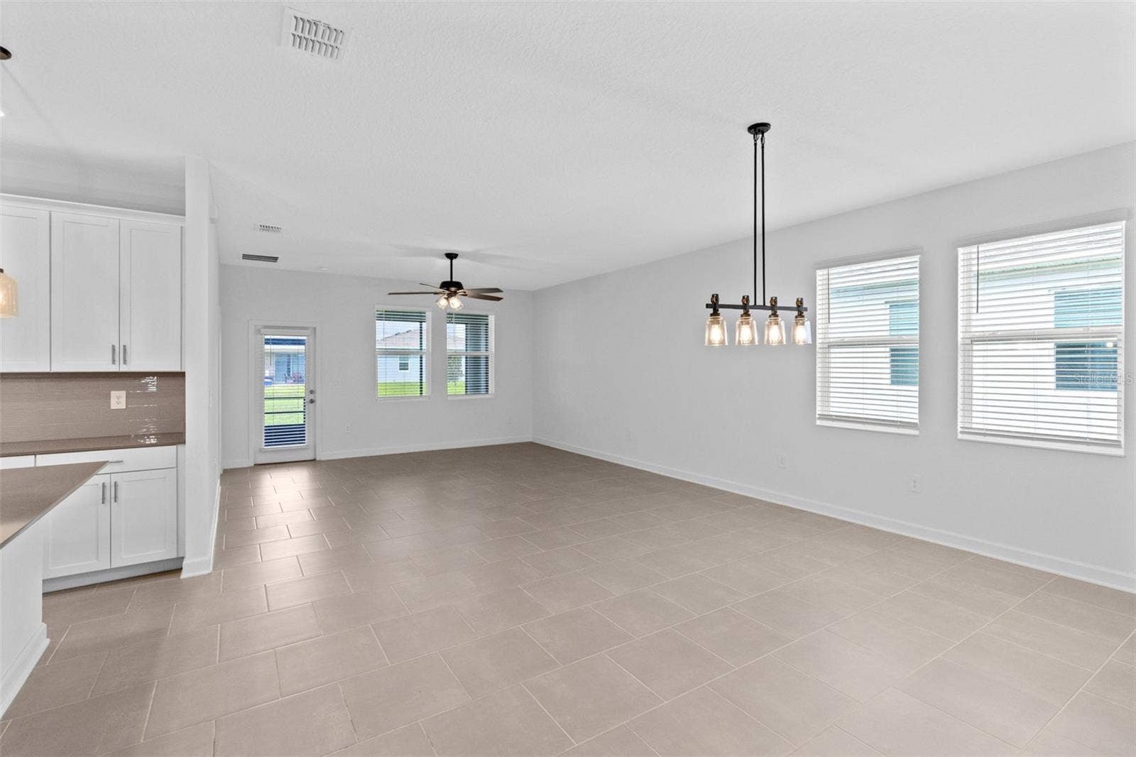 1874 FLOURISH AVENUE, Kissimmee, FL 34744 The open kitchen, dining and living spaces flow together beautifully, creating plenty of room for both everyday living and entertaining.