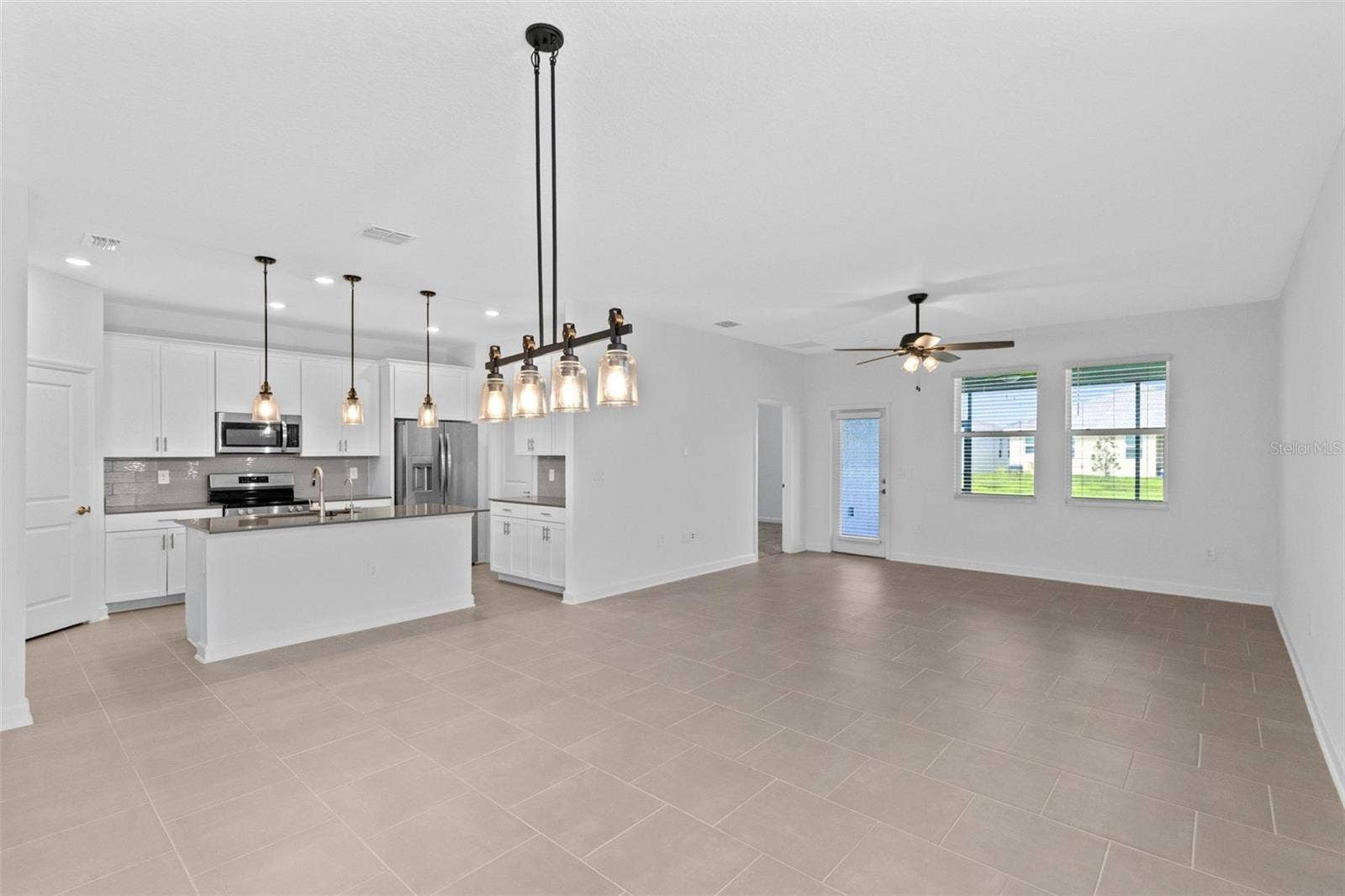 1874 FLOURISH AVENUE, Kissimmee, FL 34744 The open kitchen, dining and living spaces flow together beautifully, creating plenty of room for both everyday living and entertaining.