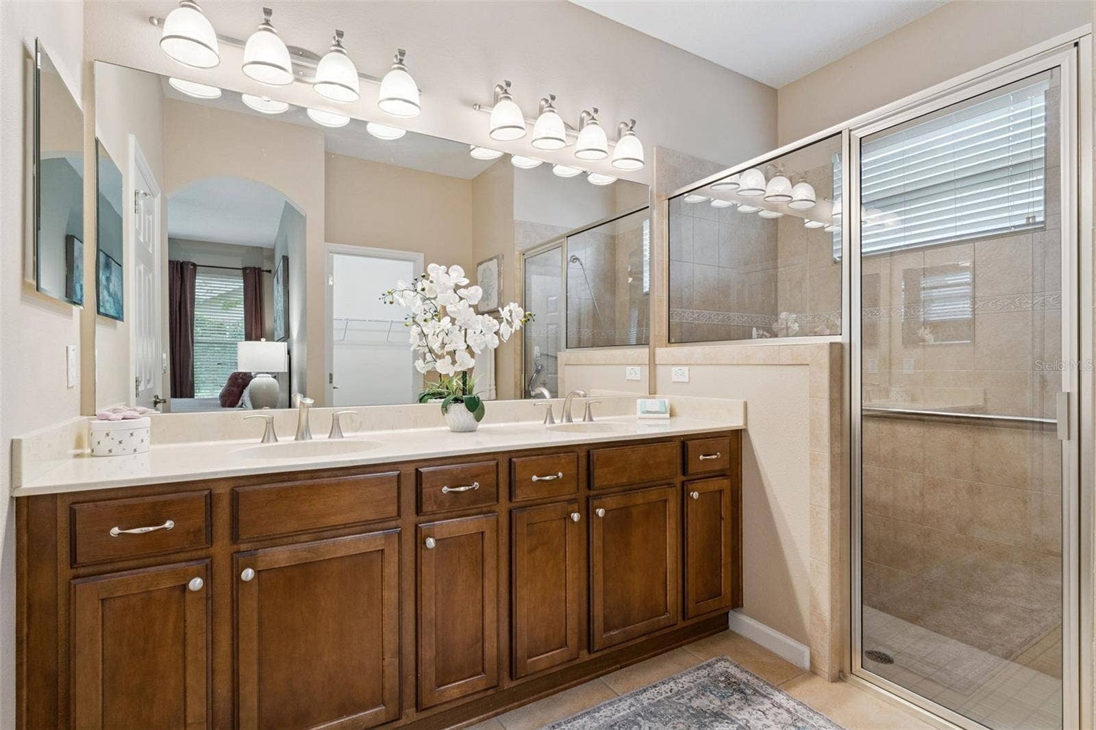 202 DRUMMOND LANE, Deland, FL 32724 Primary Bathroom w/ dual sinks, glass enclosed walk-in shower, built-in bench seat & a grab bar