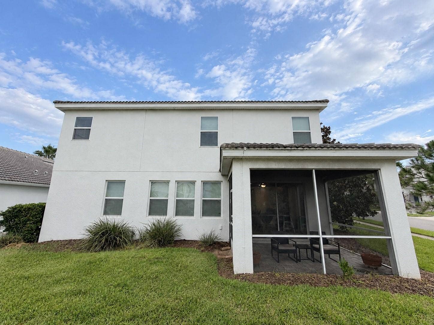 1516 BUNKER DRIVE, Davenport, FL 33896 Rear exterior showcases the home's spacious footprint and private screened outdoor living area.