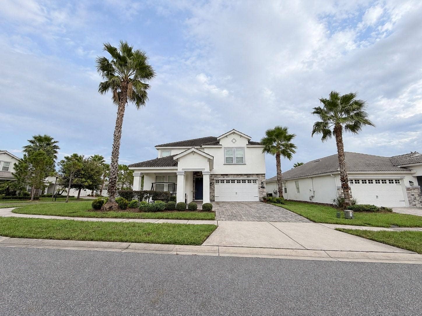 1516 BUNKER DRIVE, Davenport, FL 33896 Beautiful curb appeal with mature palm trees, manicured landscaping and a welcoming covered entry.
