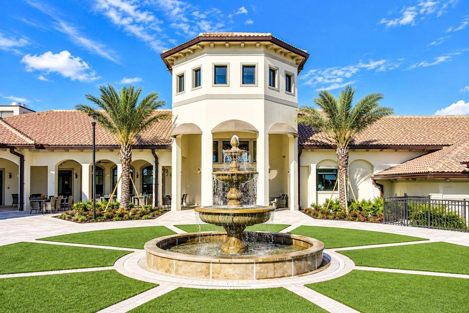 1516 BUNKER DRIVE, Davenport, FL 33896 Elegant ChampionsGate clubhouse entrance featuring Mediterranean-inspired architecture, tropical landscaping and a central fountain.