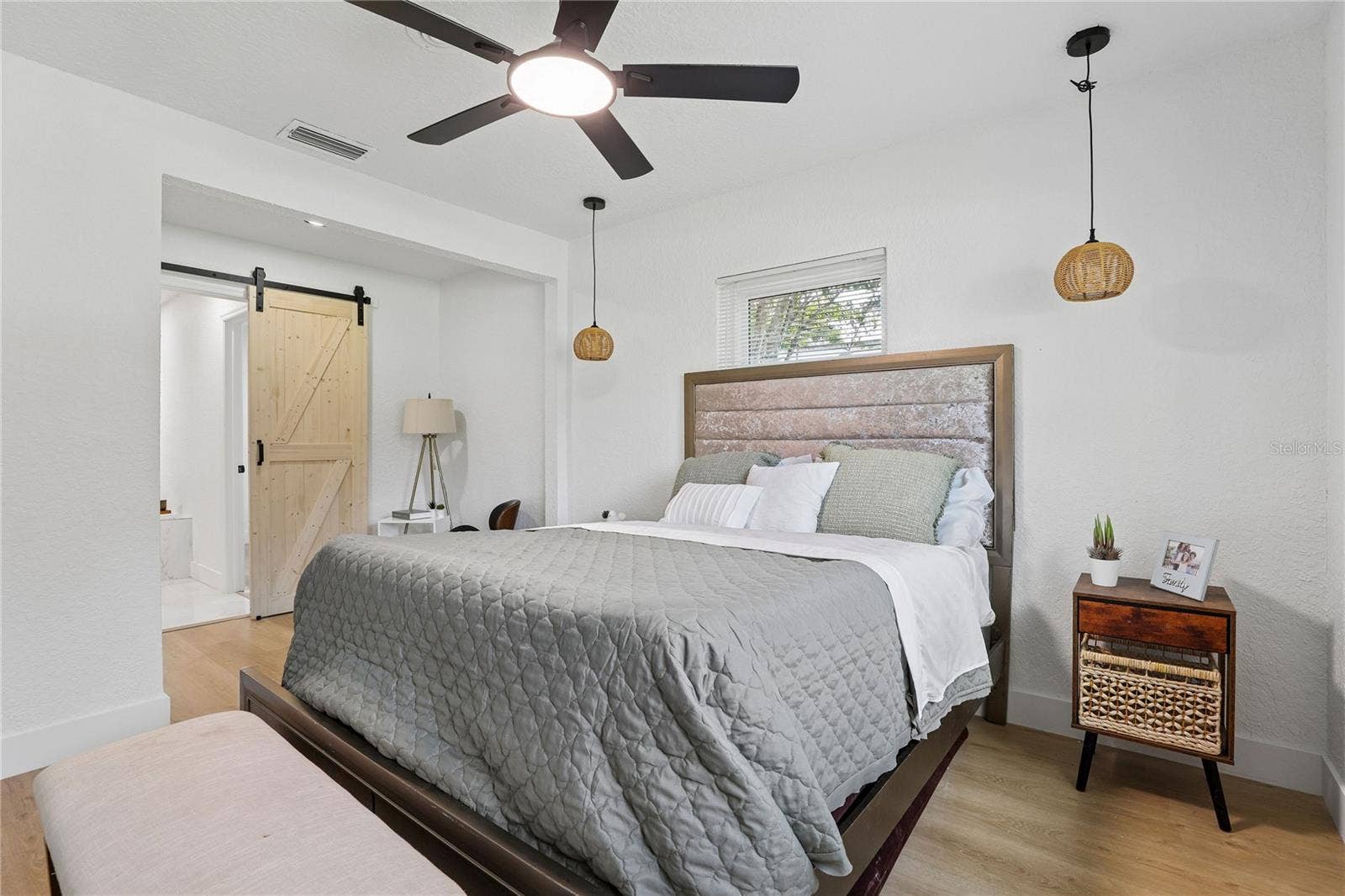 1718 CAMPBELL AVENUE, Orlando, FL 32806 Primary suite with decorative wood details, barn door and modern lighting