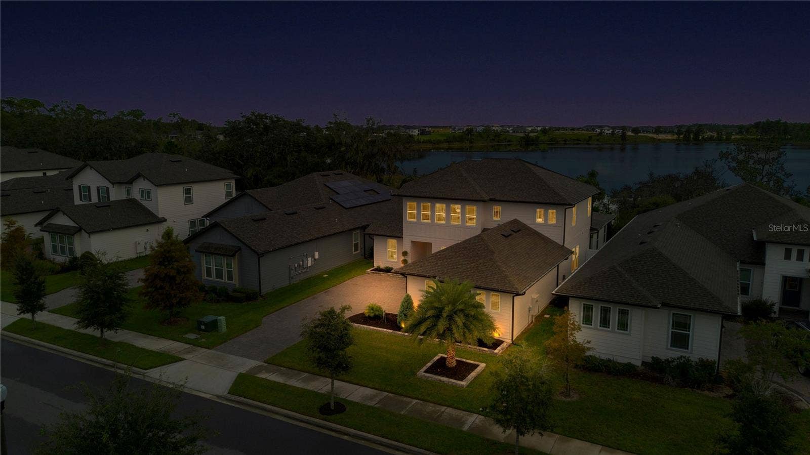 17600 LAKE STAR ROAD, Winter Garden, FL 34787 Angled twilight aerial highlights the homes exterior lighting and scenic surroundings.