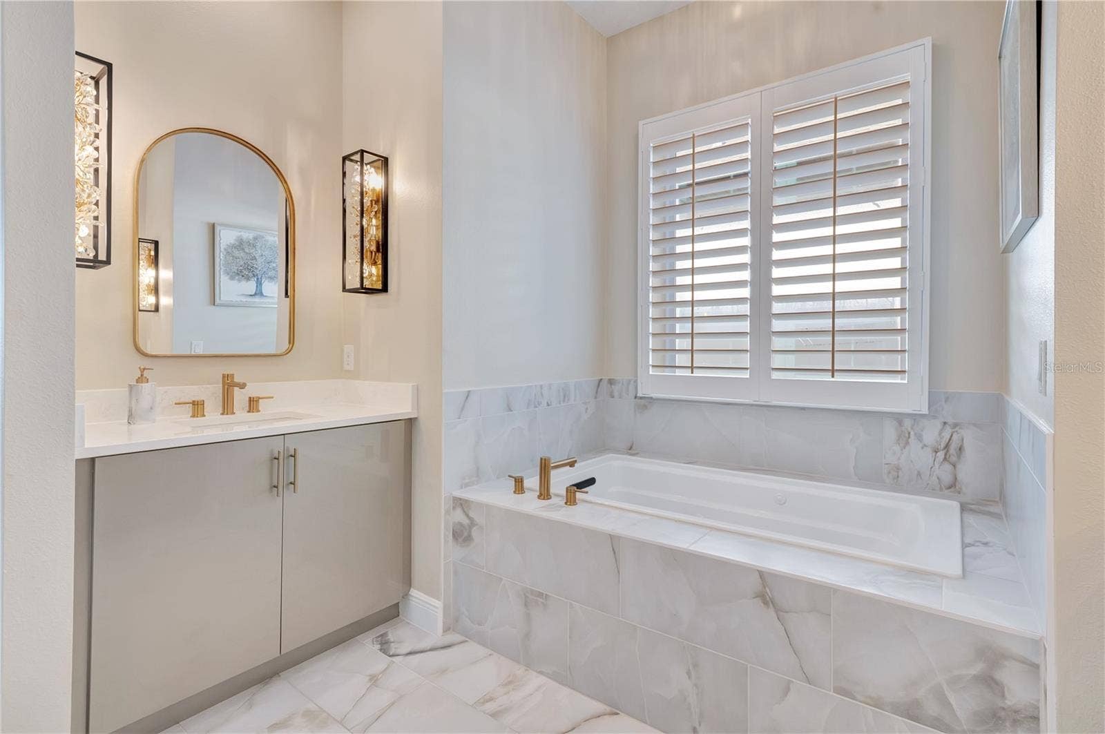 17600 LAKE STAR ROAD, Winter Garden, FL 34787 Elegant bathroom featuring a soaking tub, upgraded tile surrounds and a vanity accented by designer sconces.