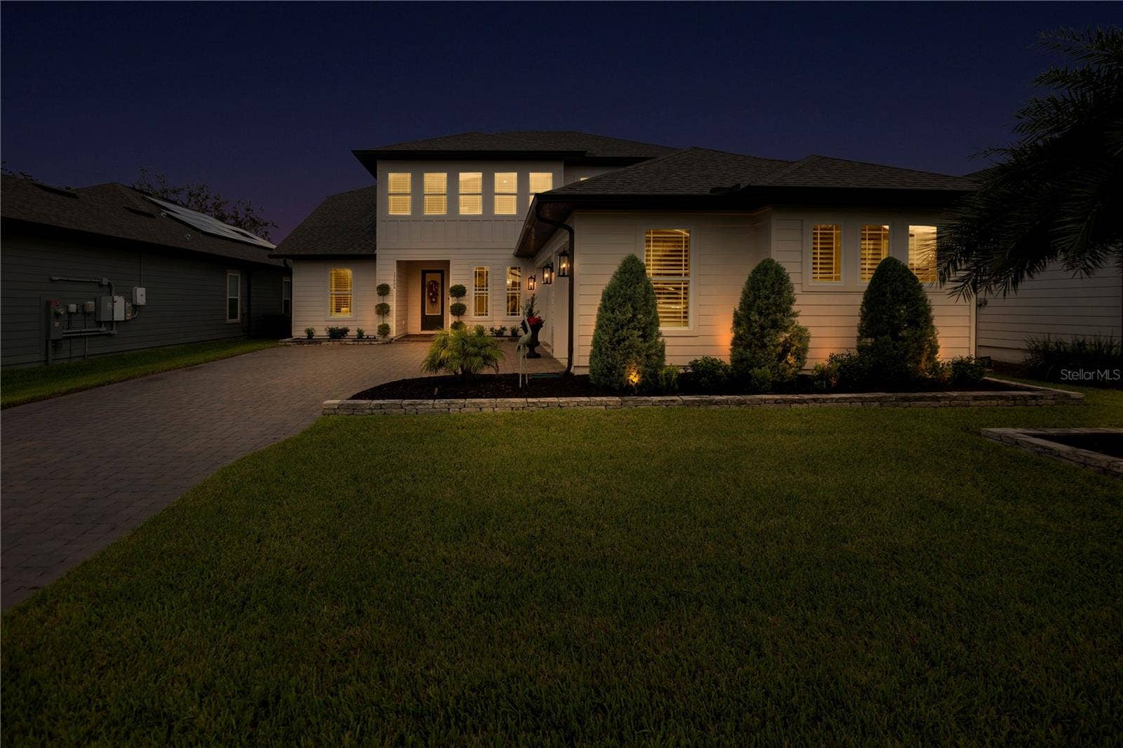 17600 LAKE STAR ROAD, Winter Garden, FL 34787 Twilight front view showcases the homes welcoming entrance and landscape lighting.