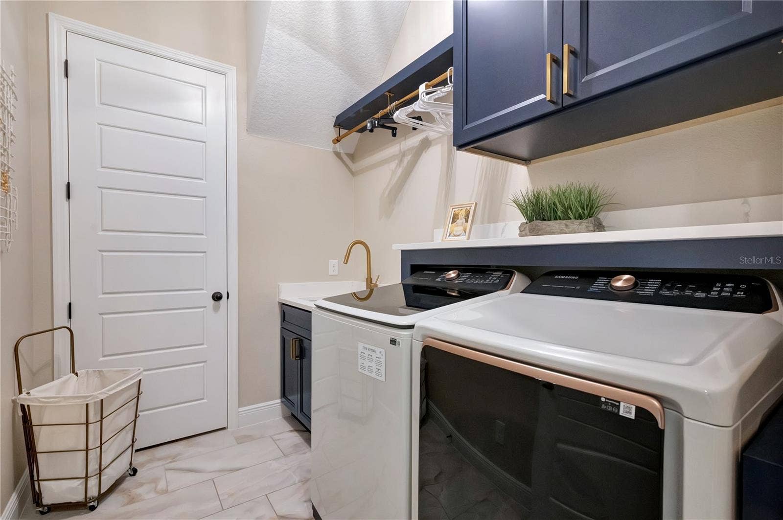 17600 LAKE STAR ROAD, Winter Garden, FL 34787 Custom laundry room featuring upgraded cabinetry, a utility sink, hanging rack and countertop above the washer and dryer.