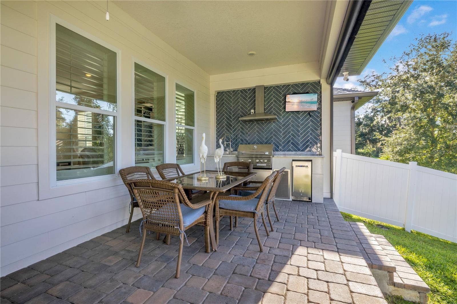 17600 LAKE STAR ROAD, Winter Garden, FL 34787 Covered outdoor dining area with a custom summer kitchen, built-in grill and beverage refrigerator.