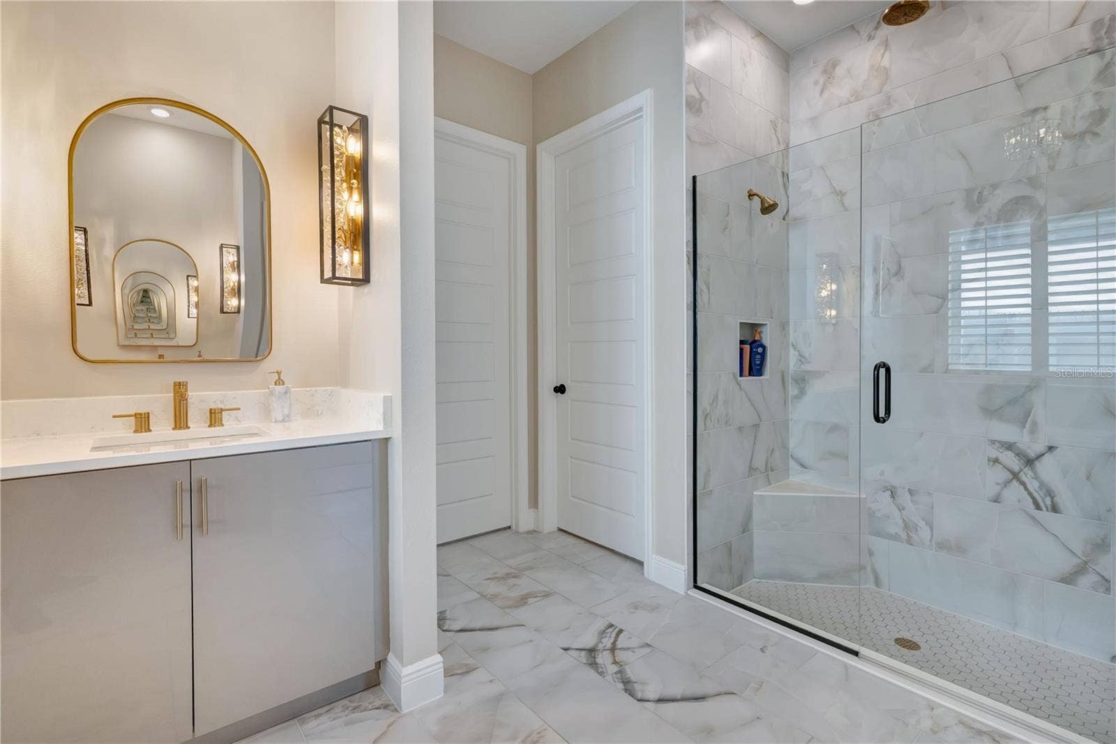 17600 LAKE STAR ROAD, Winter Garden, FL 34787 Upgraded bathroom featuring a glass-enclosed shower, floor-to-ceiling tile and a coordinating vanity with designer lighting.