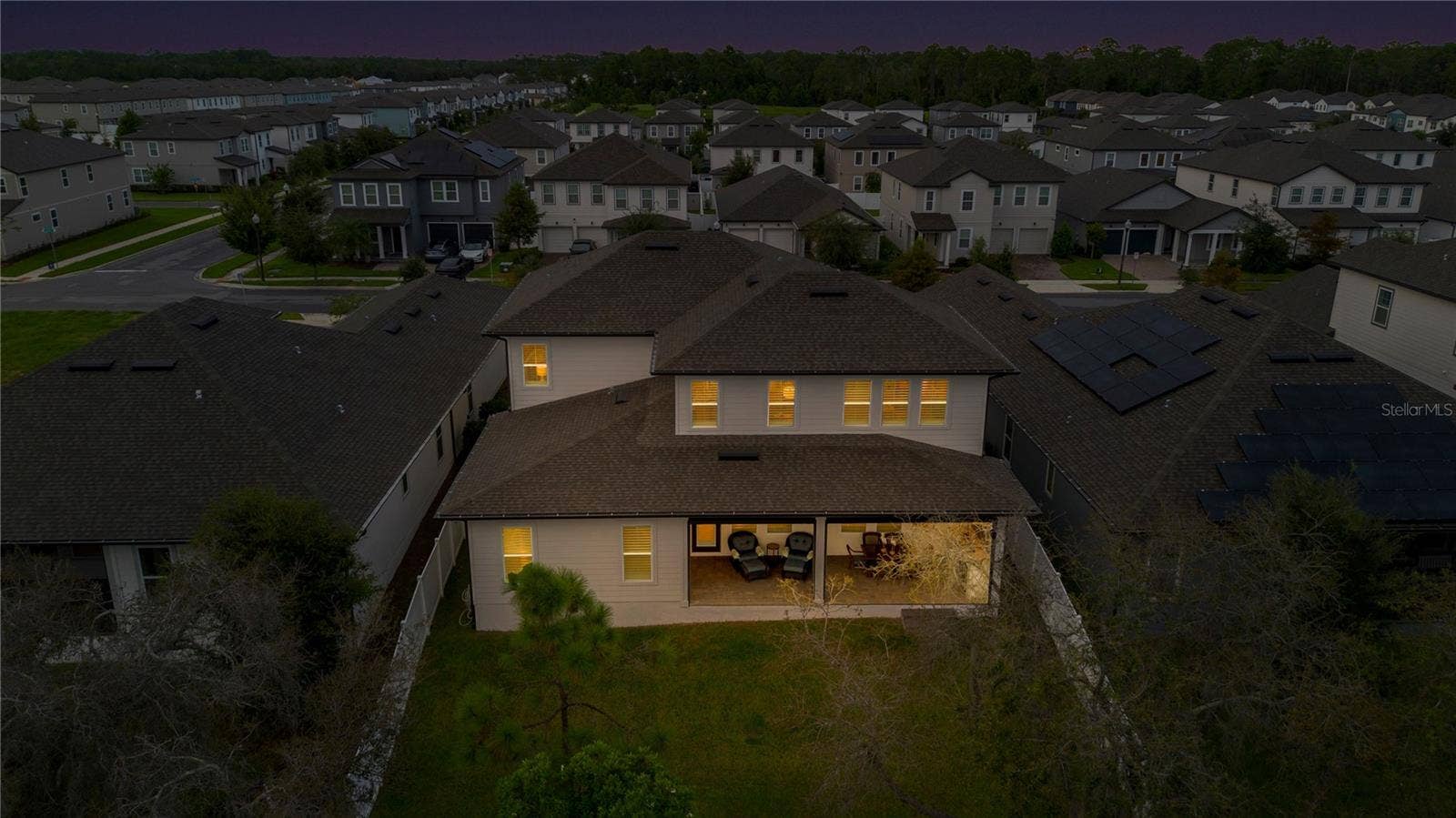 17600 LAKE STAR ROAD, Winter Garden, FL 34787 Rear aerial at twilight captures the backyard and warmly illuminated covered lanai.