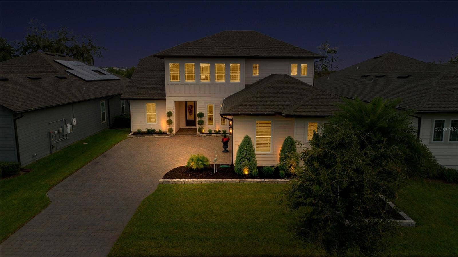 17600 LAKE STAR ROAD, Winter Garden, FL 34787 Elevated evening view highlights the front entrance, driveway and landscape lighting.