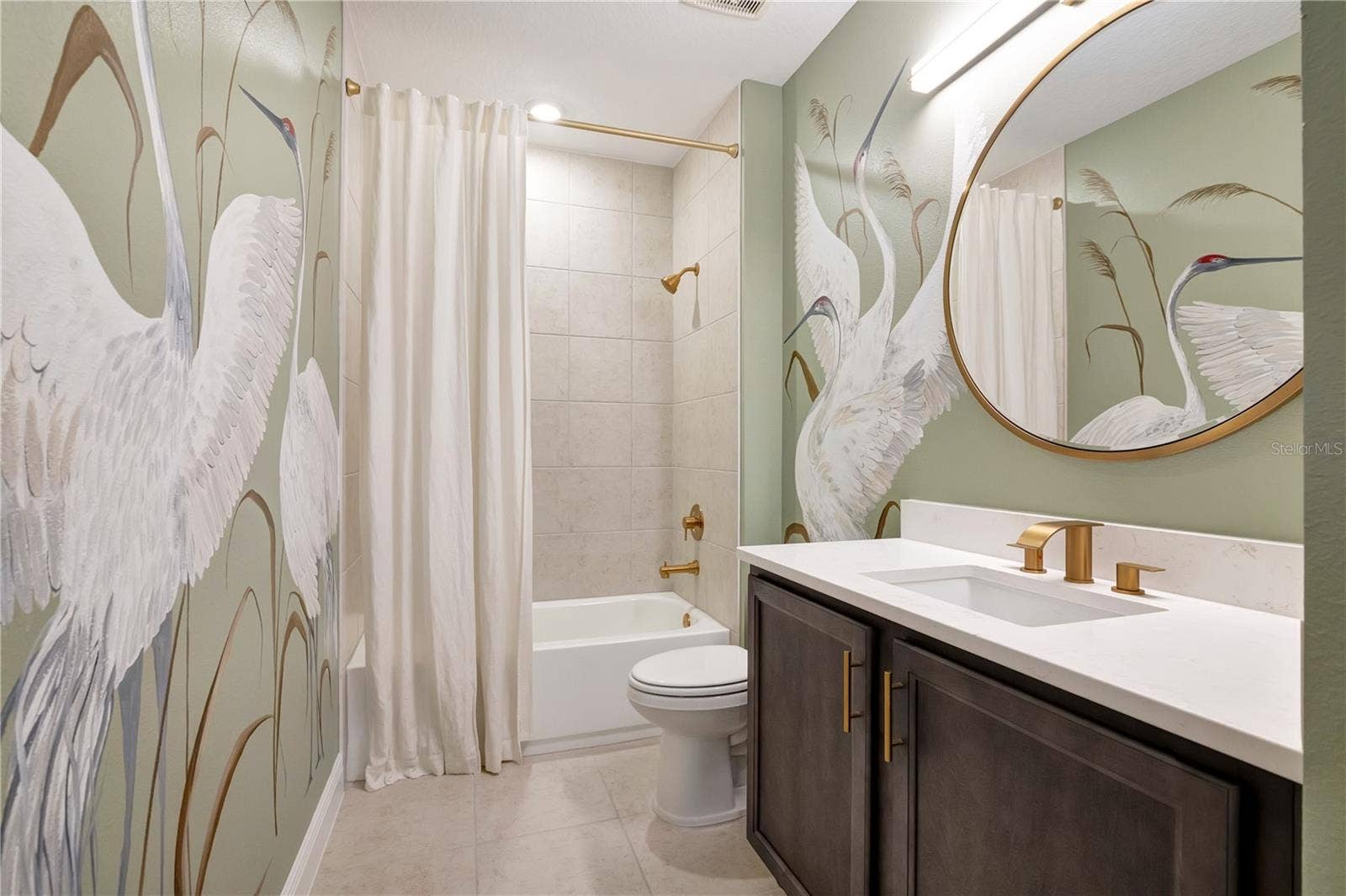 17600 LAKE STAR ROAD, Winter Garden, FL 34787 Beautifully styled bathroom featuring a bird-pattern accent wall, upgraded vanity and tub with shower.