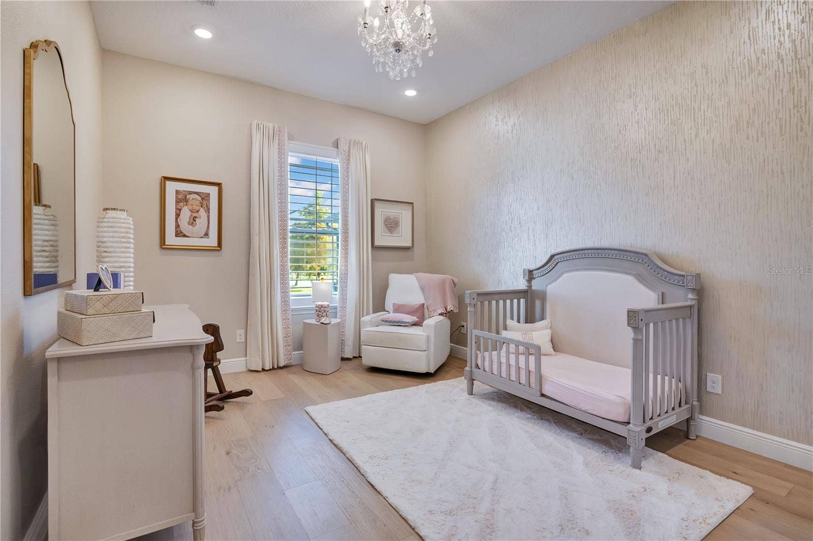 17600 LAKE STAR ROAD, Winter Garden, FL 34787 Charming bedroom featuring hardwood flooring, a decorative accent wall and chandelier lighting.