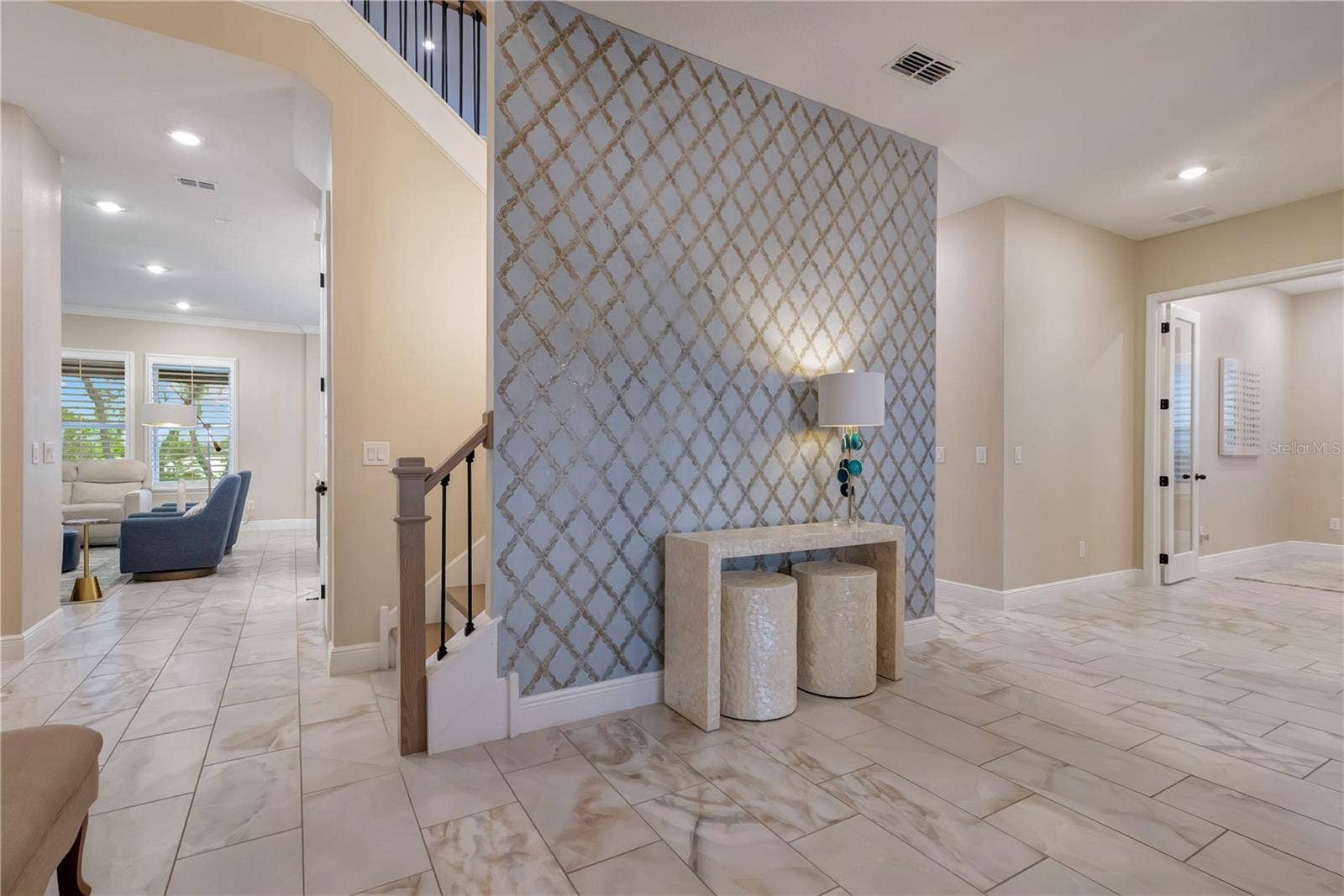 17600 LAKE STAR ROAD, Winter Garden, FL 34787 Statement accent wall highlights the entryway, with an open staircase and views into the main living areas.