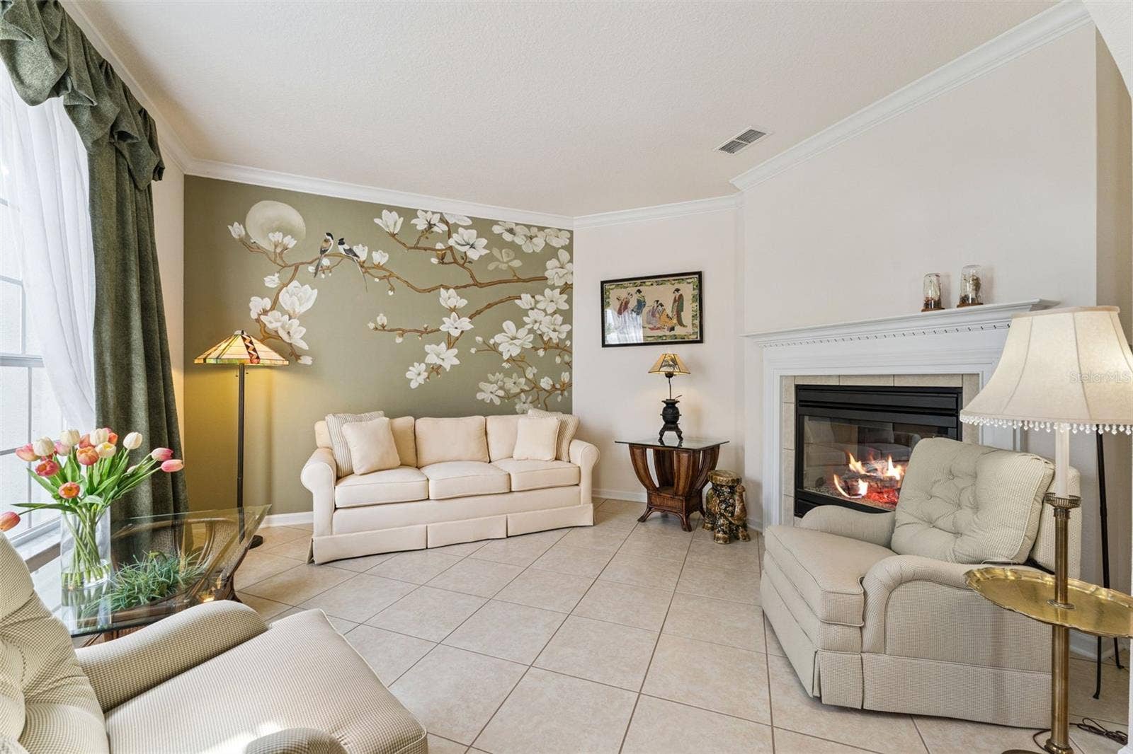 108 AVENHAM DRIVE, Deland, FL 32724 12' x 14' Living Room w/ crown molding, accent wall & a double sided natural gas fireplace