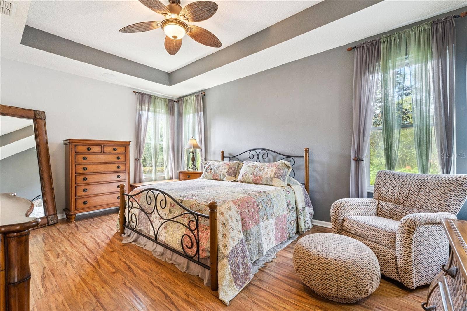 108 AVENHAM DRIVE, Deland, FL 32724 18'6" x 13' Primary Bedroom w/ engineered wood flooring, tray ceiling, ceiling fan & a private conservation area view
