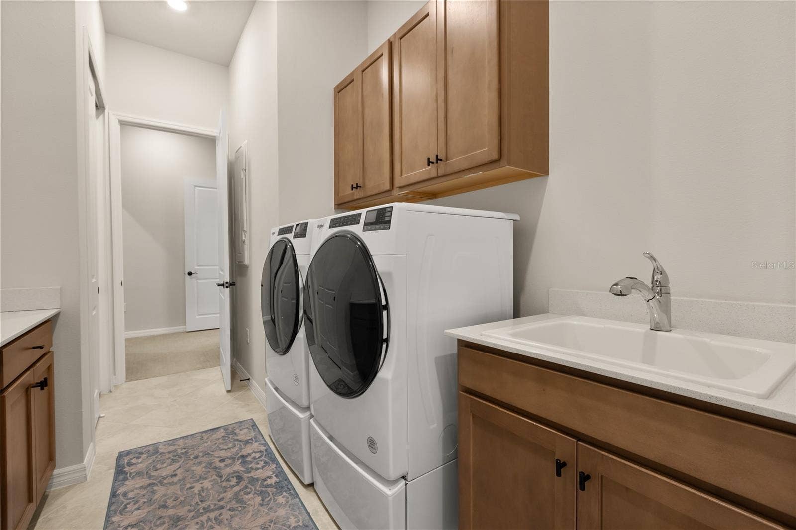 Oversized, gorgeous laundry room with sink and tons of space for storage