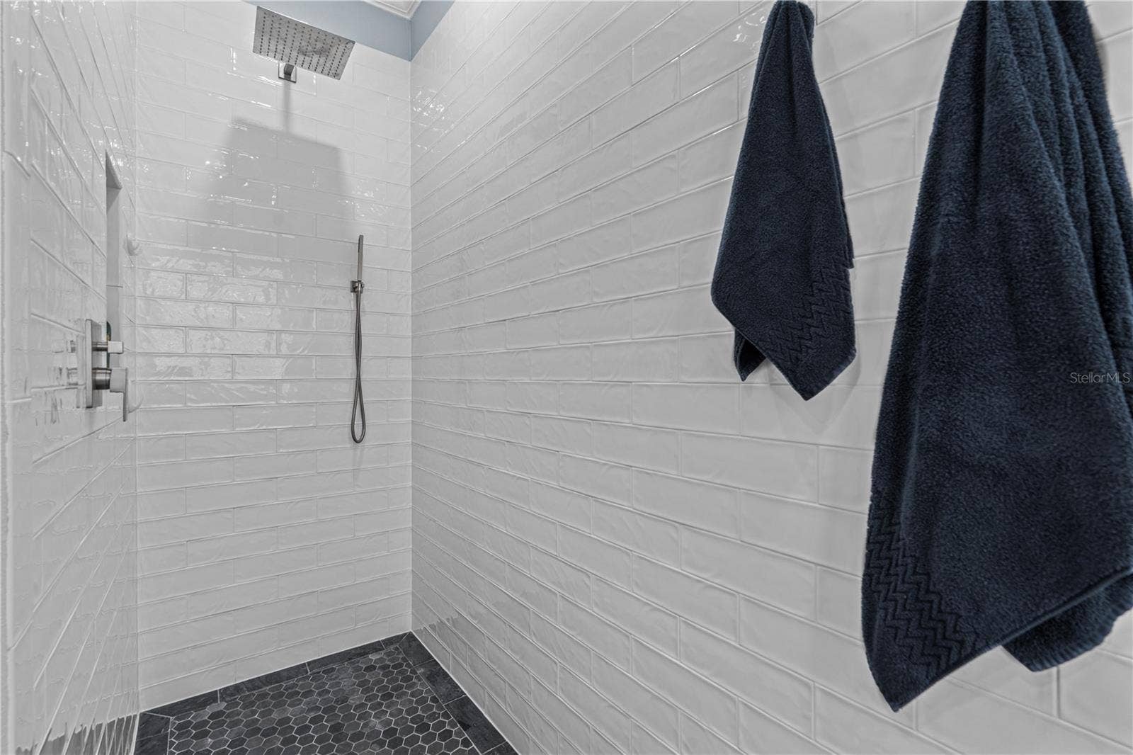 520 SOTHEBY WAY, Debary, FL 32713 Walk-in/roll-in (no threshold) shower with rain shower head and spray wand; A storage niche is tucked away on the left