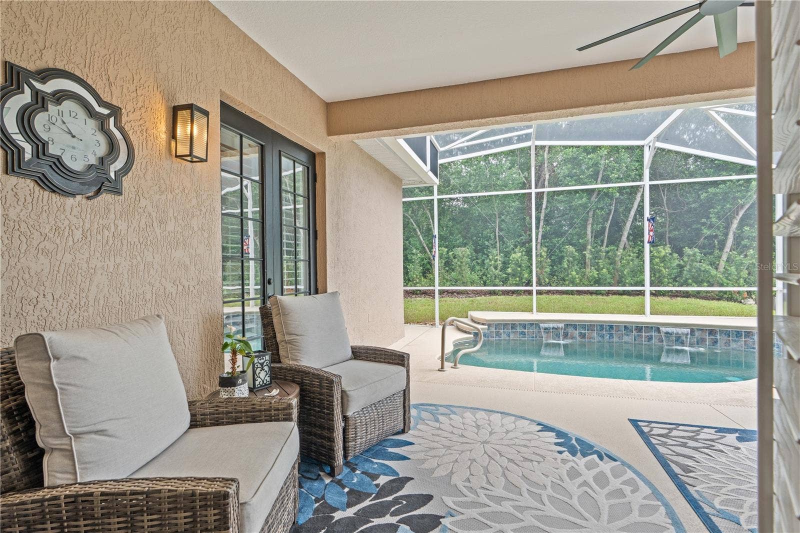 520 SOTHEBY WAY, Debary, FL 32713 Looking out the French doors in the Great Room toward the refreshing pool -- the buffer of trees and shrubs offers privacy from the golf course just beyond