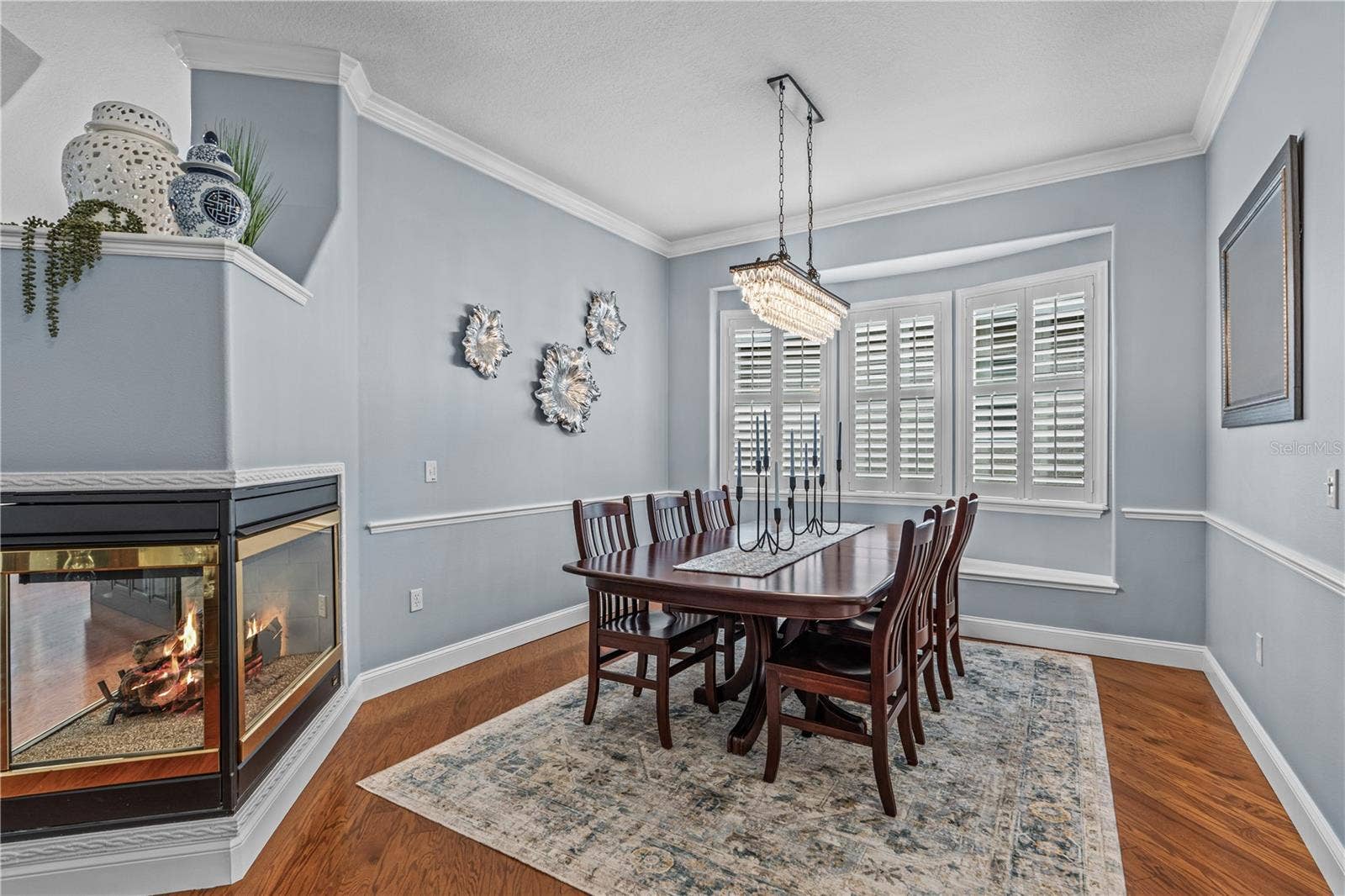 520 SOTHEBY WAY, Debary, FL 32713 Dining room with decorative chair rail and window seat (behind the table); The fireplace is natural gas and adds warmth & ambiance