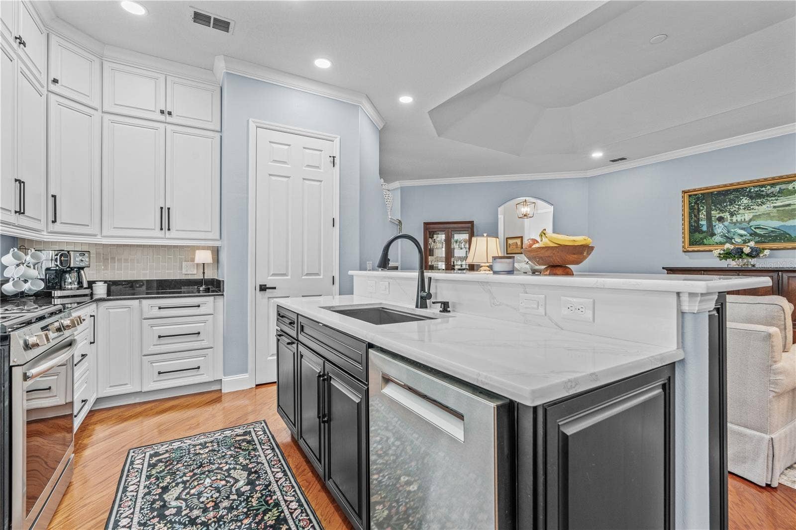 520 SOTHEBY WAY, Debary, FL 32713 Quartz counters on the island surround a large, single bowl stainless steel sink; The door adjacent to the island is the closet pantry