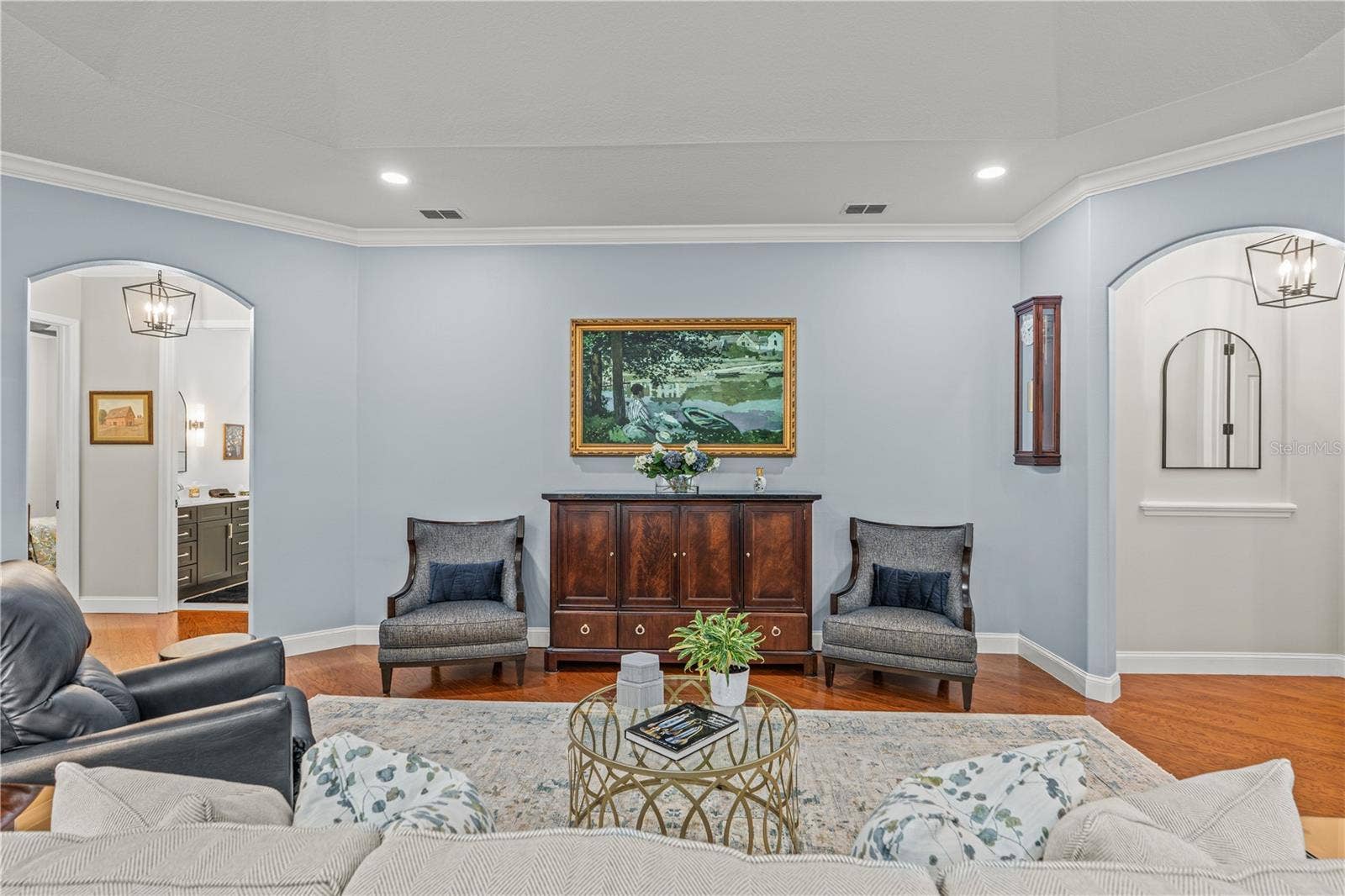 520 SOTHEBY WAY, Debary, FL 32713 The "painting" over the cabinet is actually the TV! The arched hallway to the right leads to the primary suite and the arched hallway to the left takes you to the 2 guest rooms and laundry room