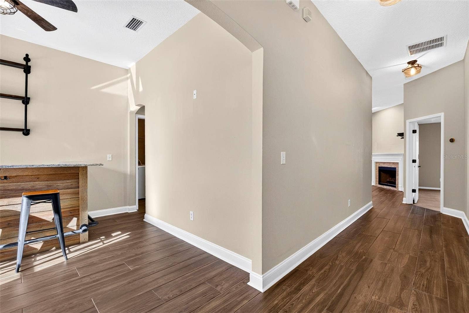 View from front door. Hallway straight ahead and dining room/bar to the left.