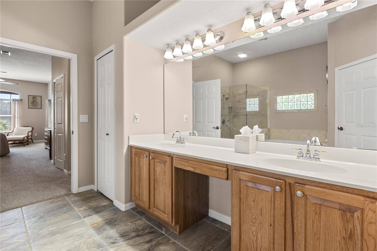 Primary bathroom featuring double vanity sinks, soak in tub and shower