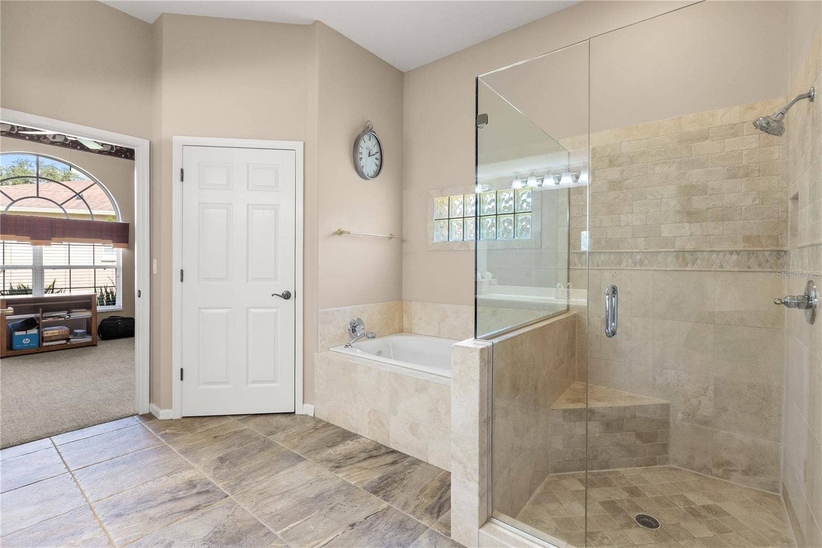 Primary bathroom featuring double vanity sinks, soak in tub and shower