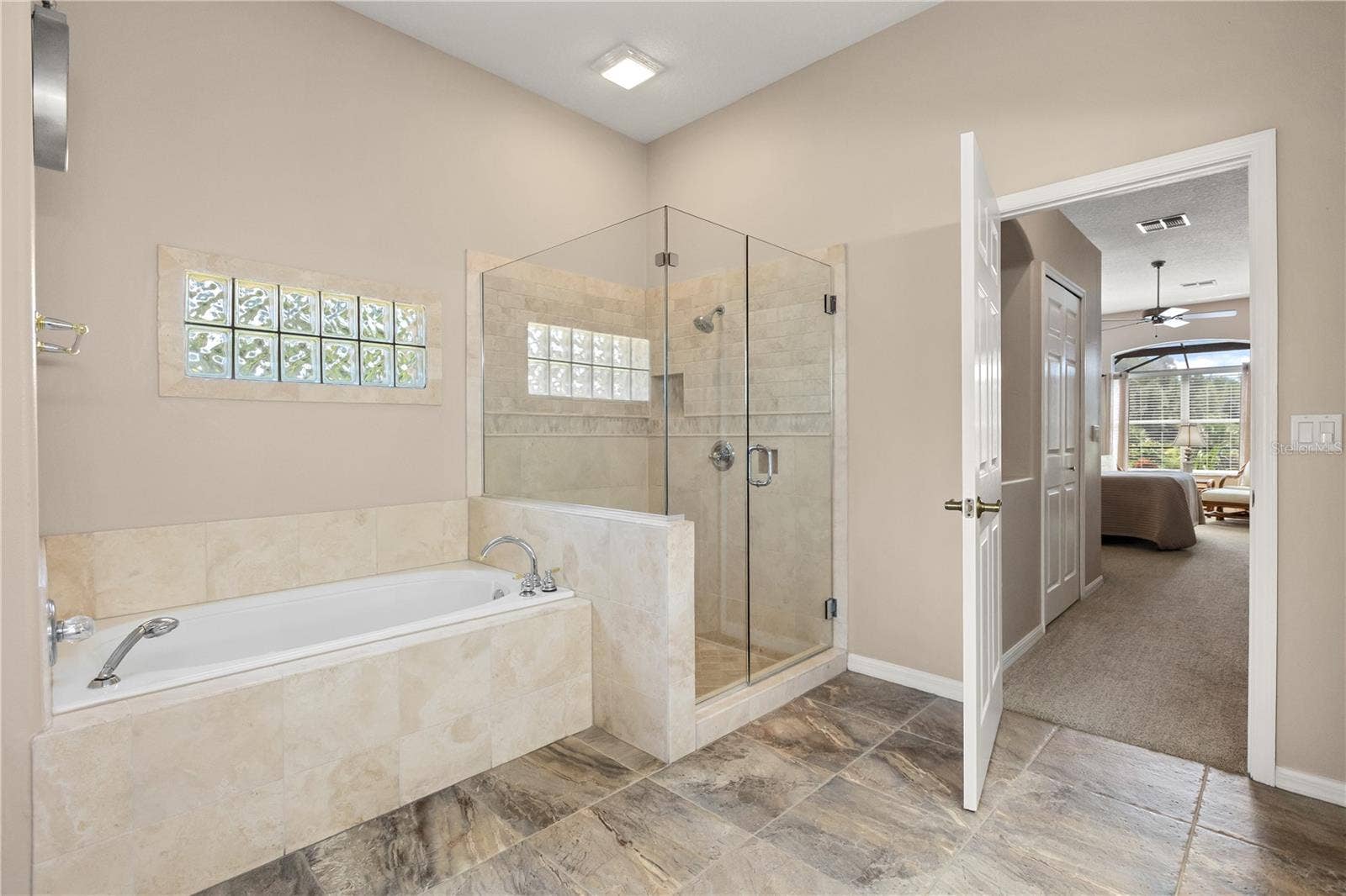 Primary bathroom featuring double vanity sinks, soak in tub and shower