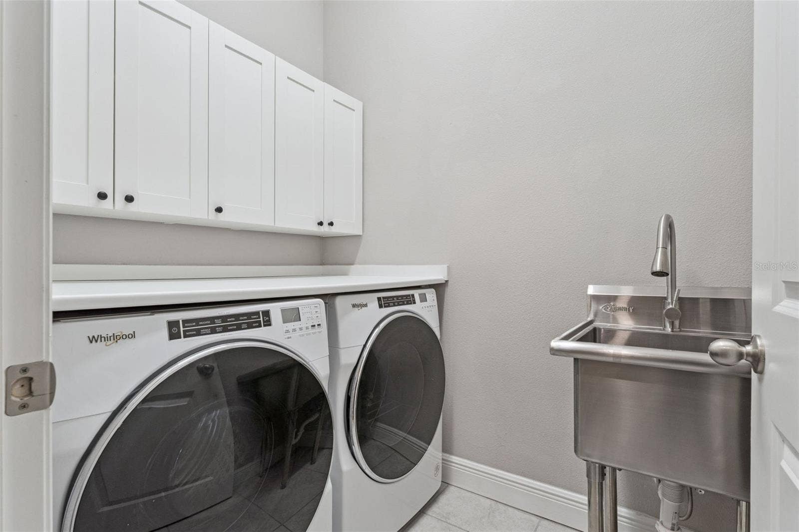 19058 PLANETREE STREET, Orlando, FL 32827 Convenient laundry room with upper cabinetry and space for full-size appliances.